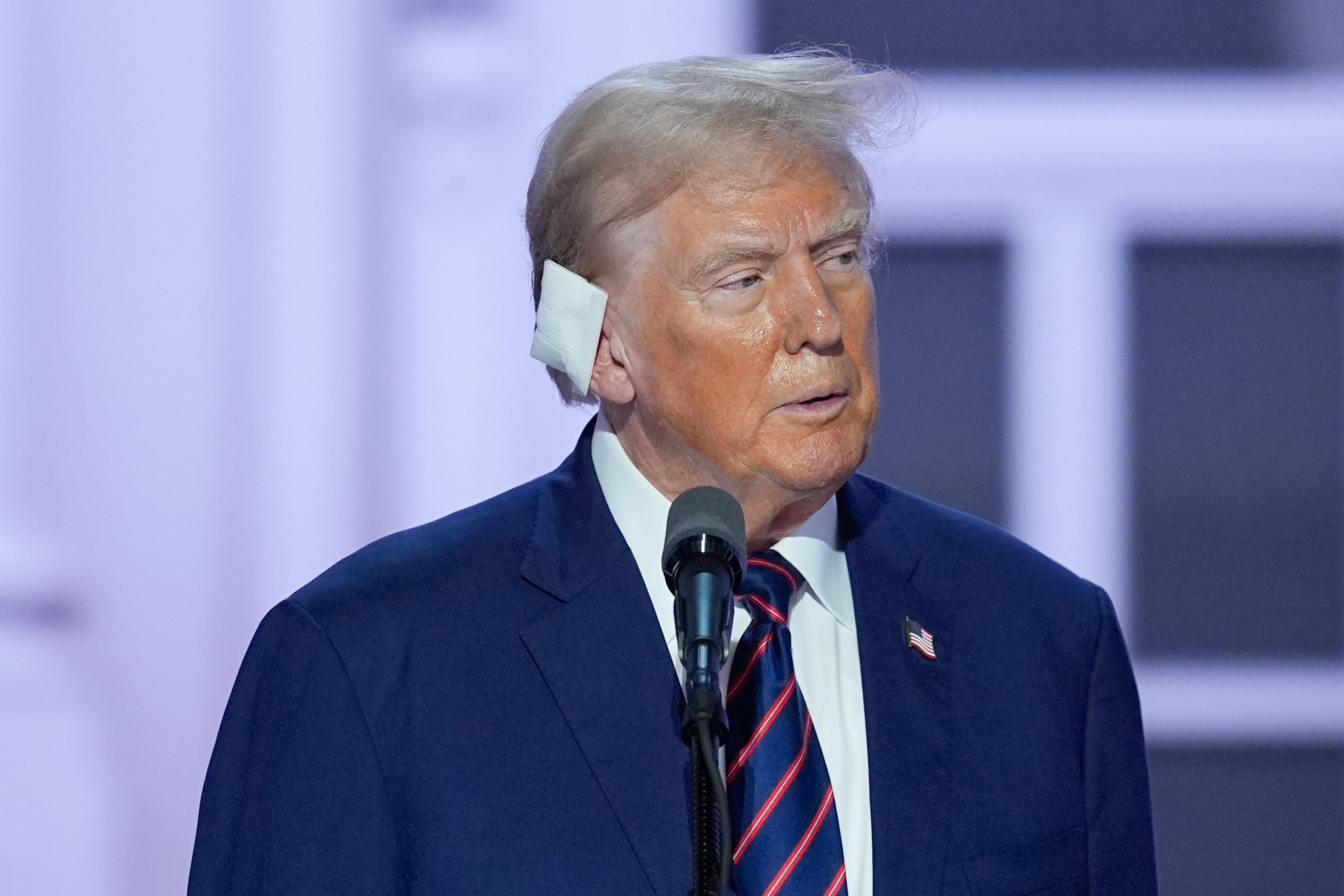 Trump on stage during the Republican National Convention wearing a bandage on his ear after surviving an assassination attempt