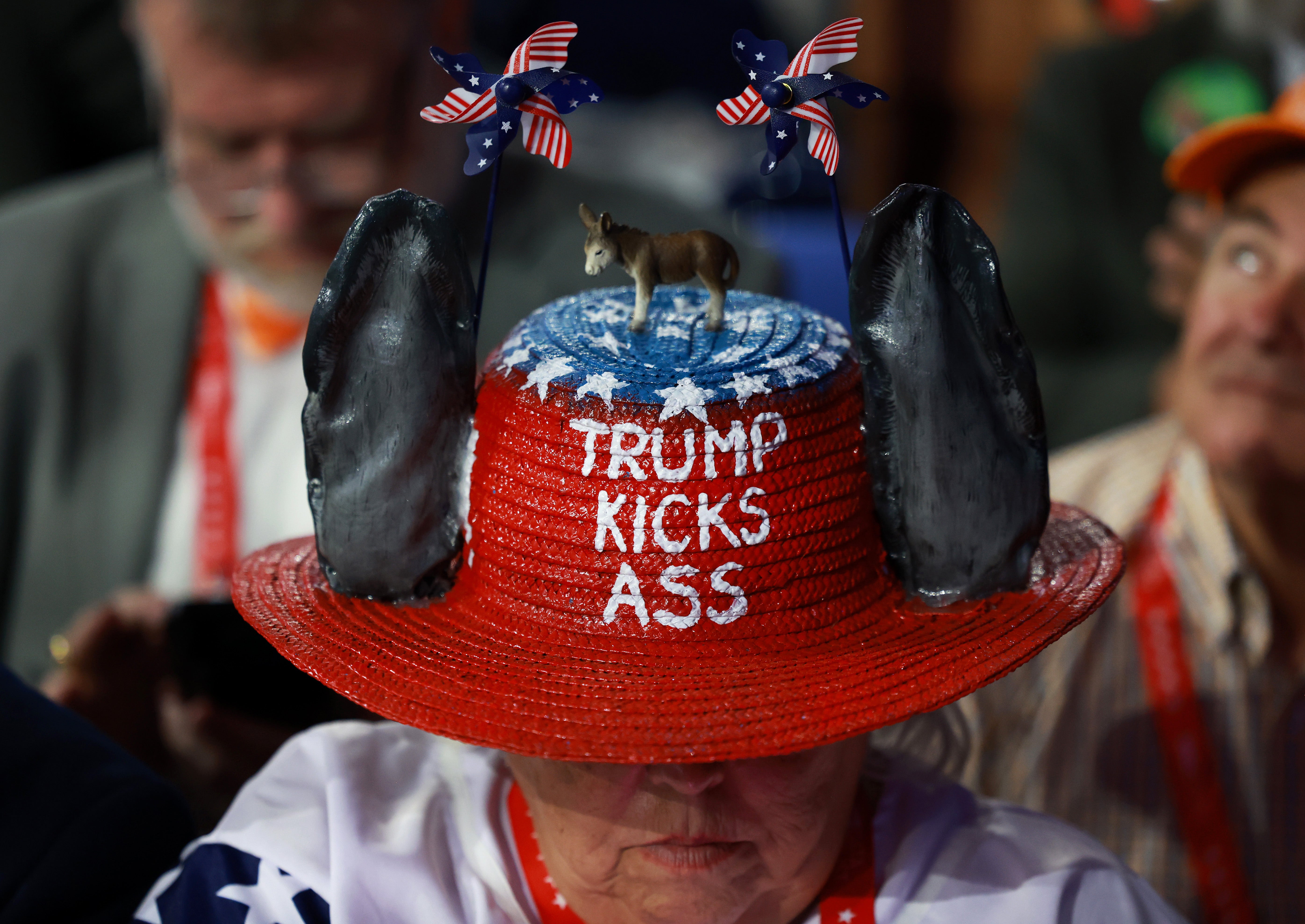 A woman wears a decorated hat that reads ‘Trump Kicks Ass’. The GOP presidential campaign is pushing a narrative of strength versus weakness, accusing Joe Biden of not being up to the job