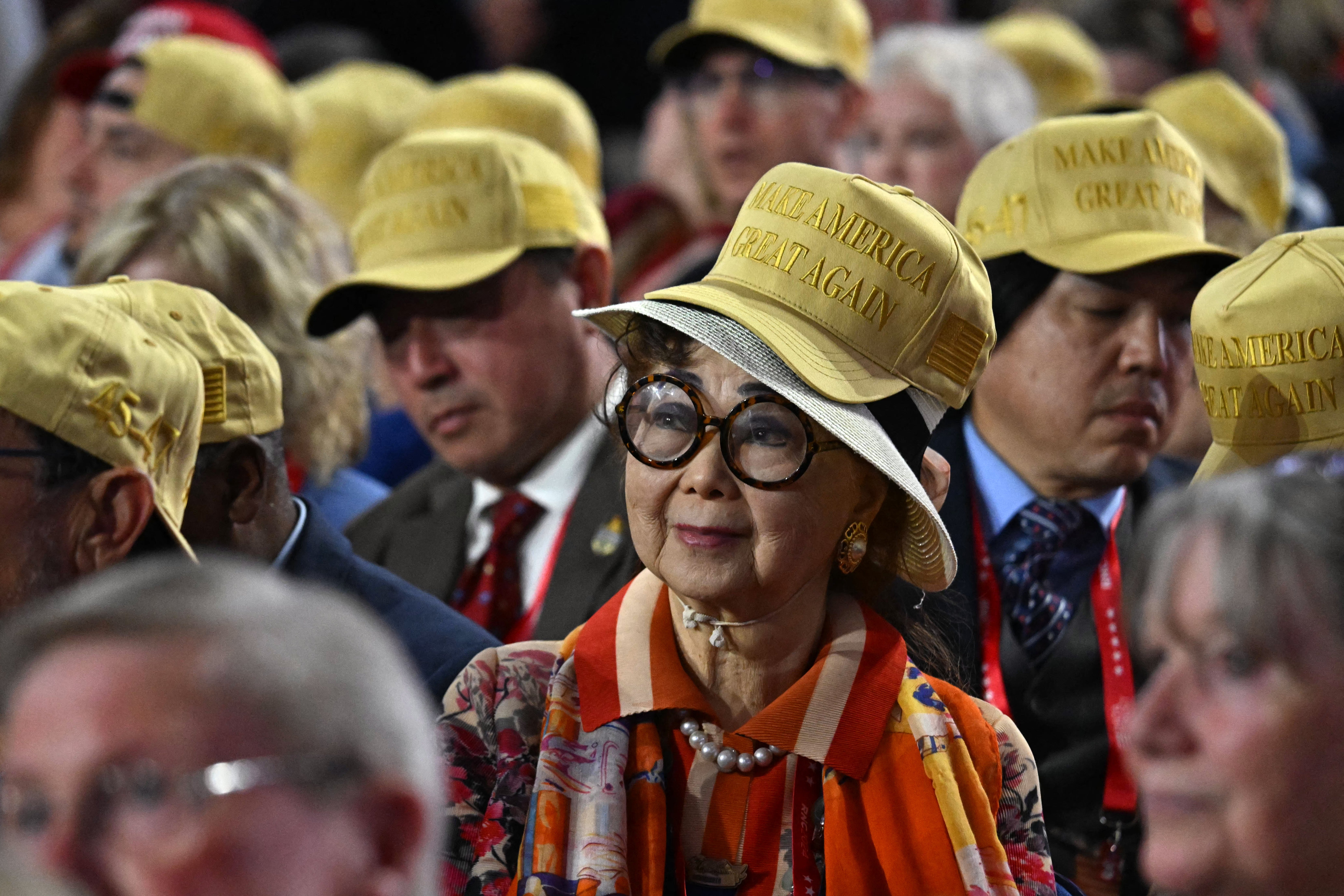 Delegates wear yellow MAGA hats rather than the more traditional red ones