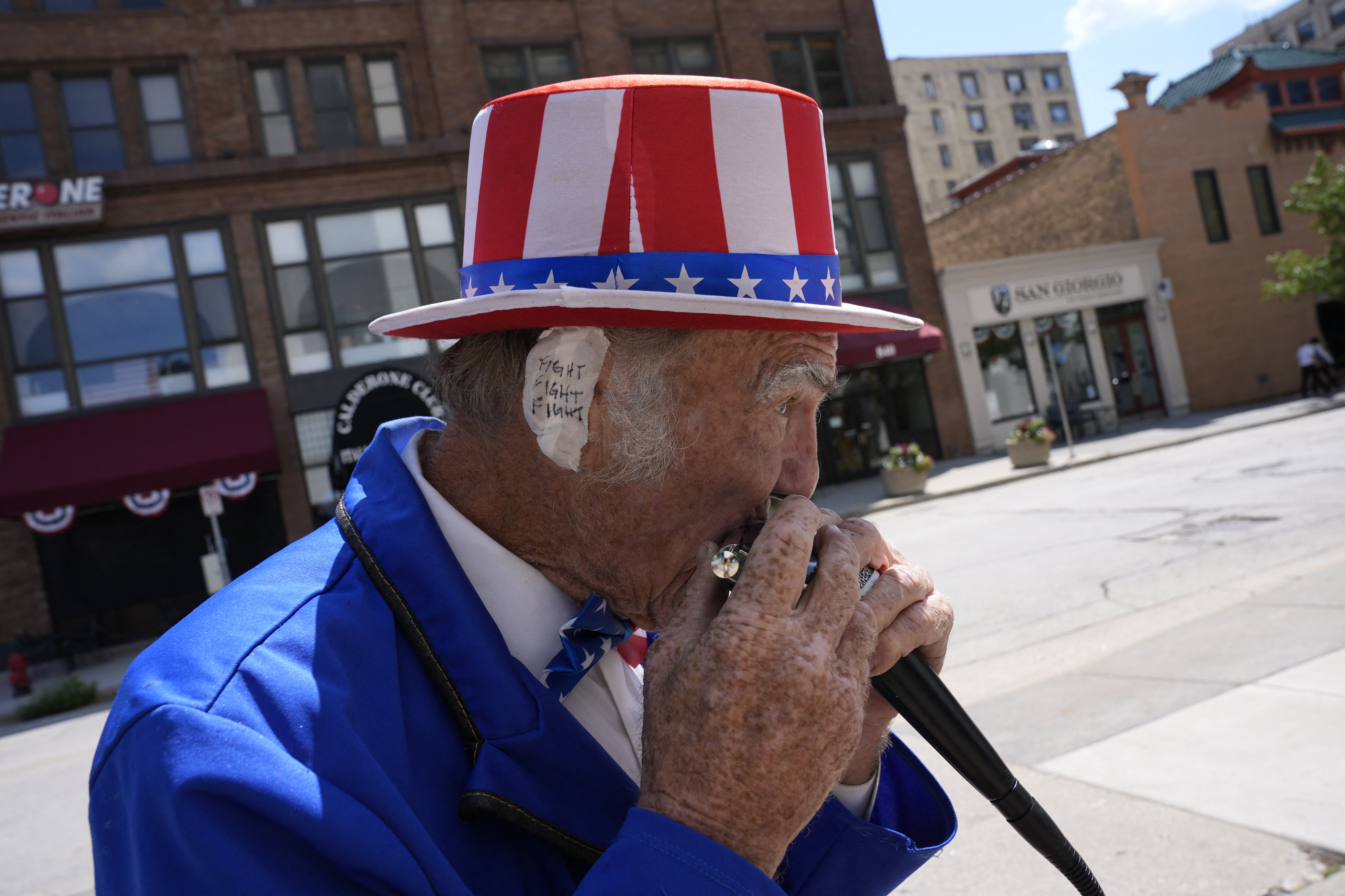 Duane Schwingel, dressed as Uncle Sam, plays harmonica outside the Fiserv Forum