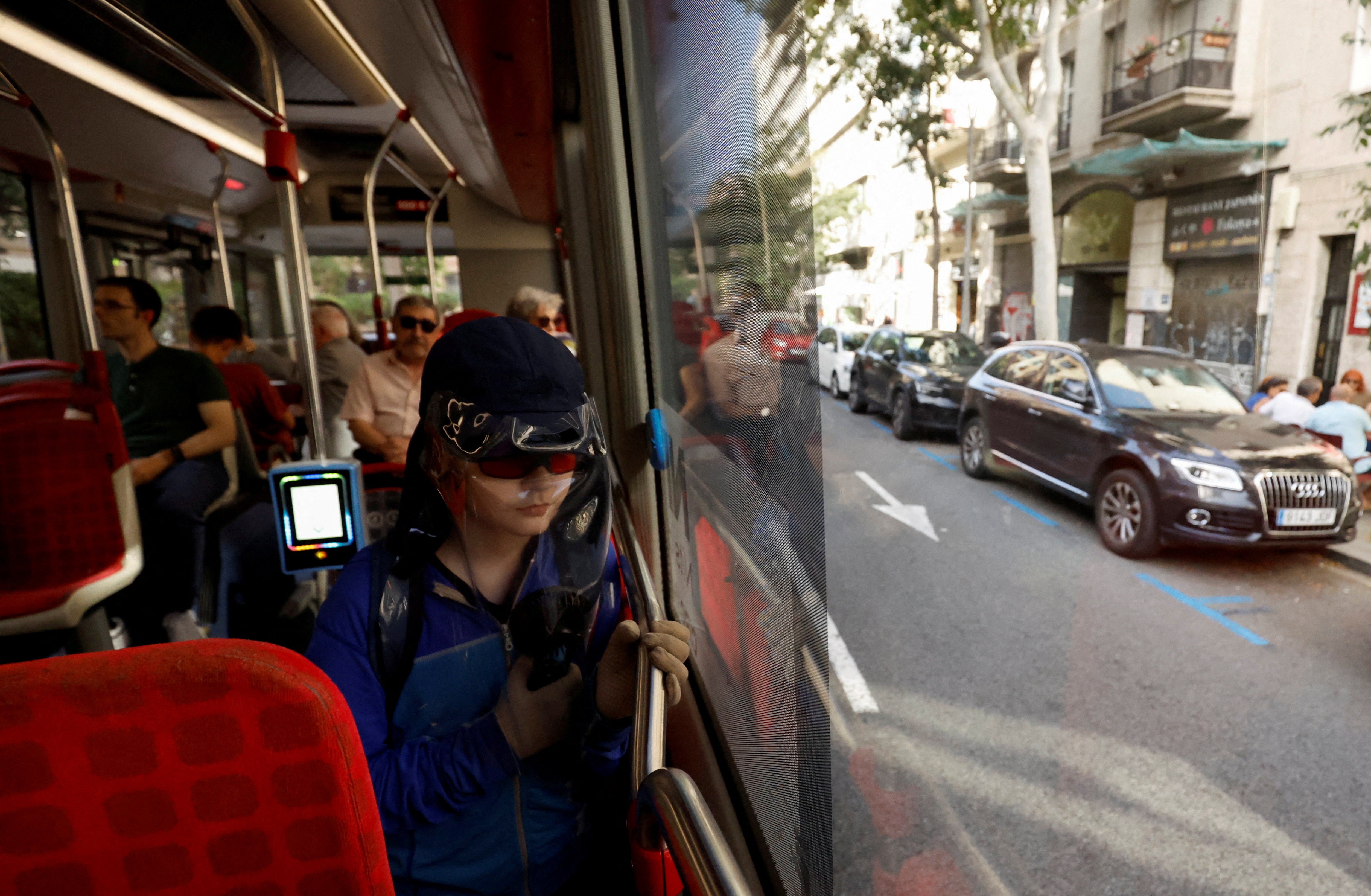 Pol Dominguez Aranda, 11, who is diagnosed with Xeroderma pigmentosum - extreme sensitivity to ultraviolet rays - looks to the street as he travels by bus with UV protections in Barcelona, Spain