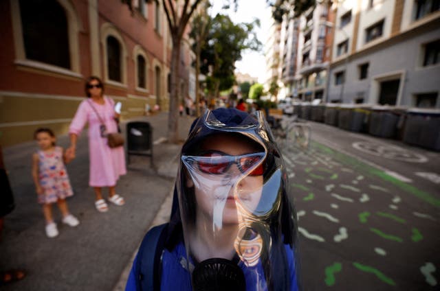 <p>Pol Dominguez Aranda, 11, who is diagnosed with Xeroderma pigmentosum - extreme sensitivity to ultraviolet rays - walks the street in shadowed areas wearing UV protection gear</p>