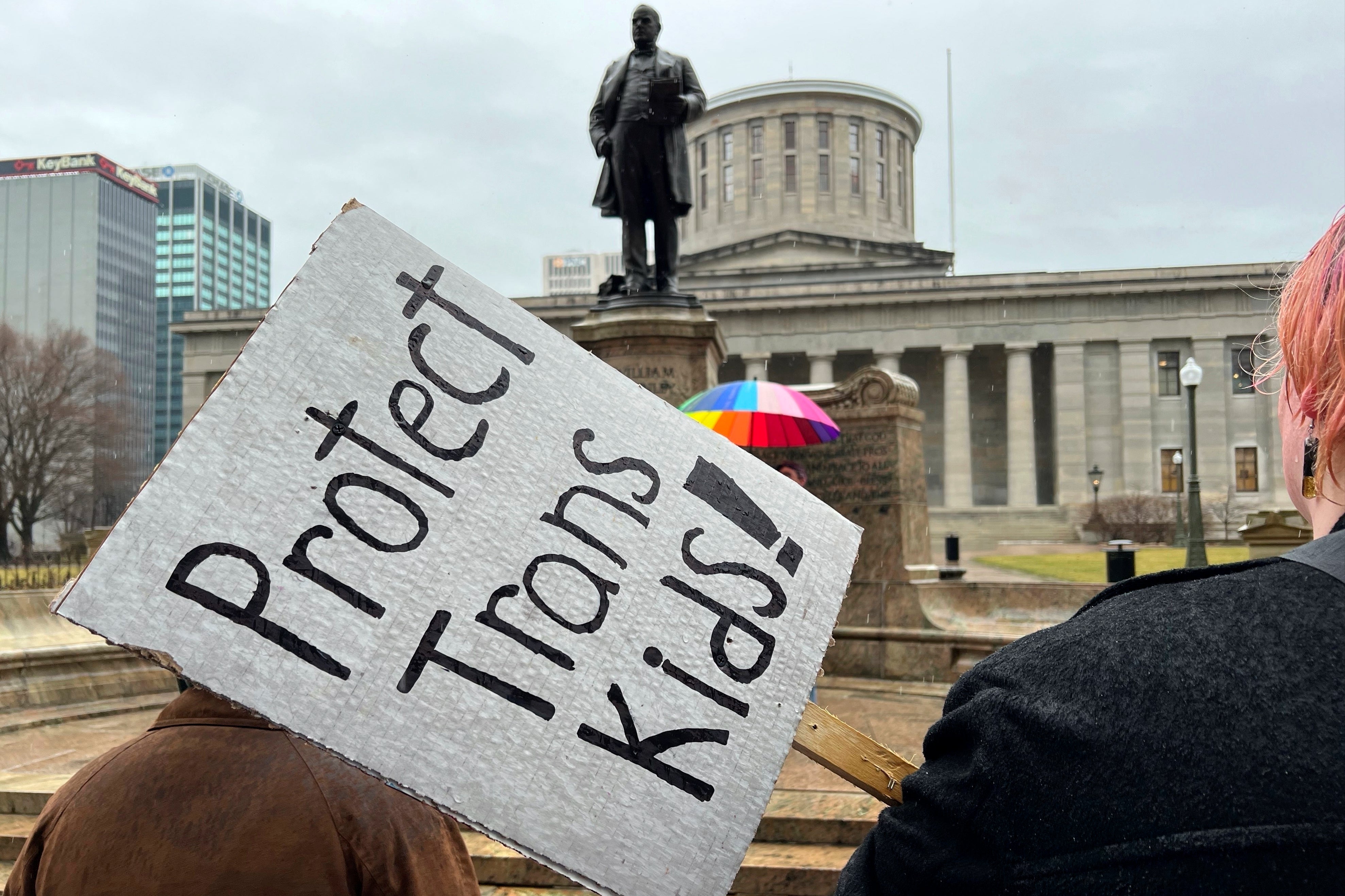 Demonstrators advocating for transgender rights and healthcare stand outside of the Ohio Statehouse, Jan. 24, 2024, in Columbus, Ohio