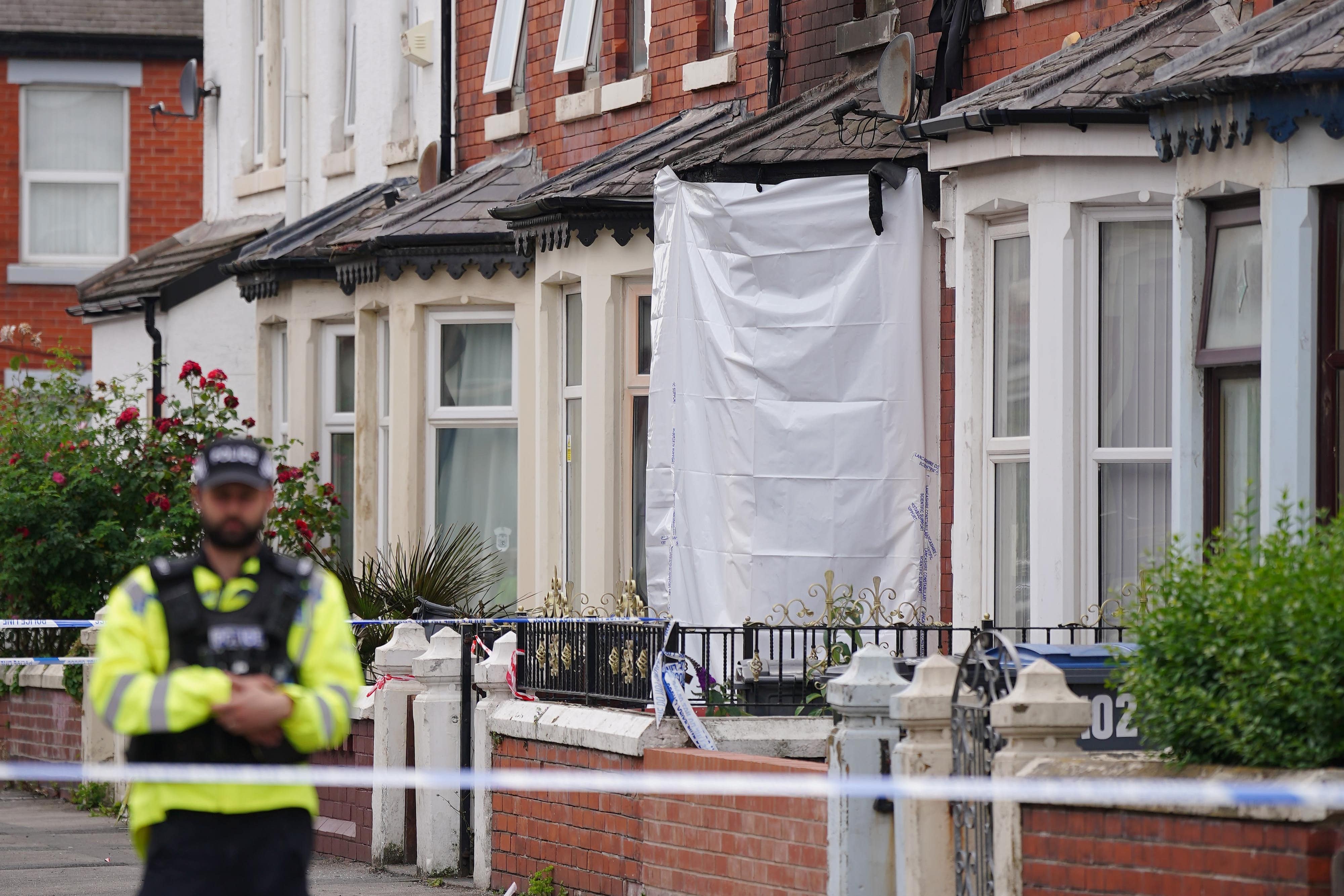 A police officer near a house in Blackpool after a man and a woman died (Peter Byrne/PA)