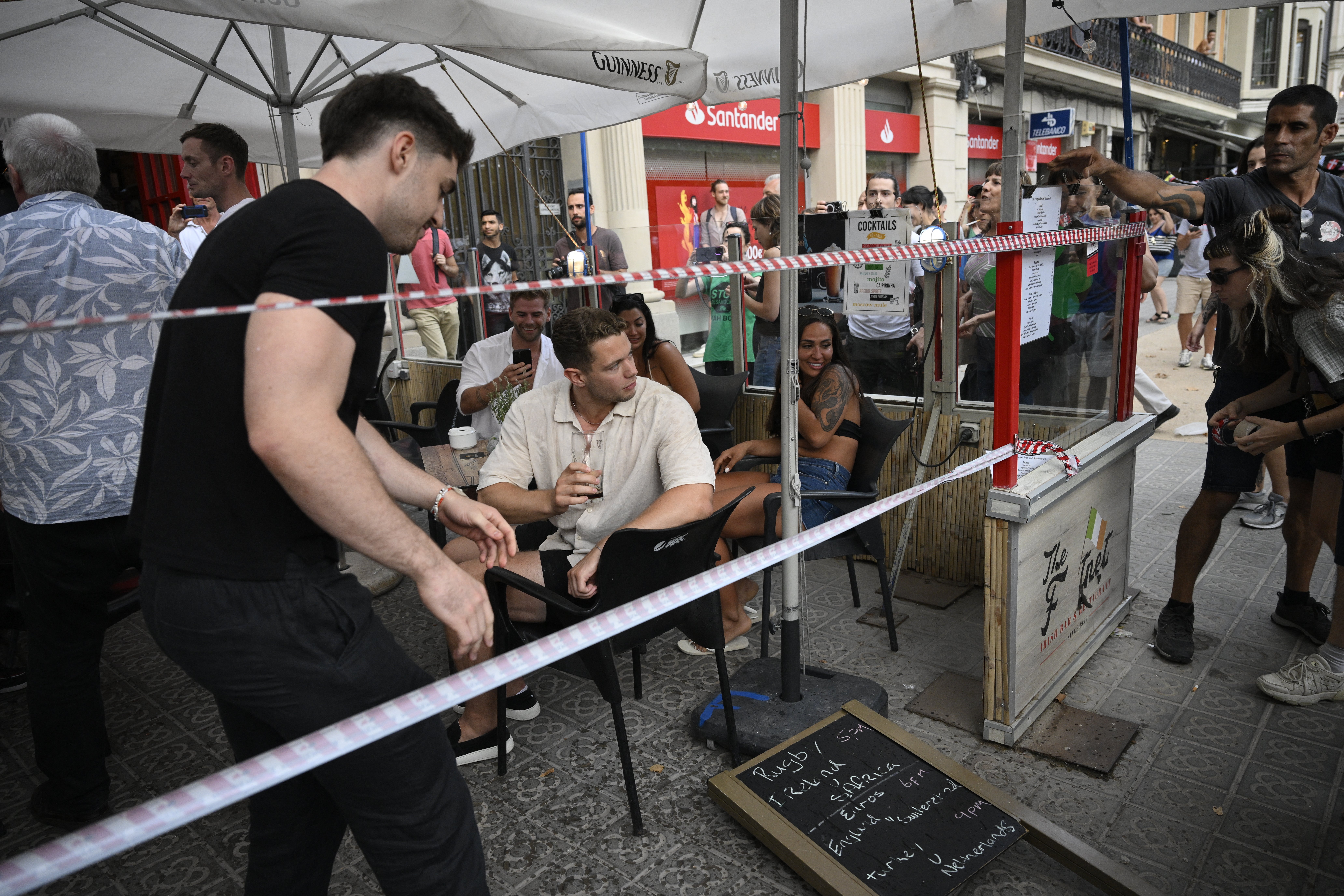 Manifestantes colocam cordão simbólico na vitrine de um bar-restaurante durante um protesto contra o turismo de massa em Barcelona, ​​Espanha