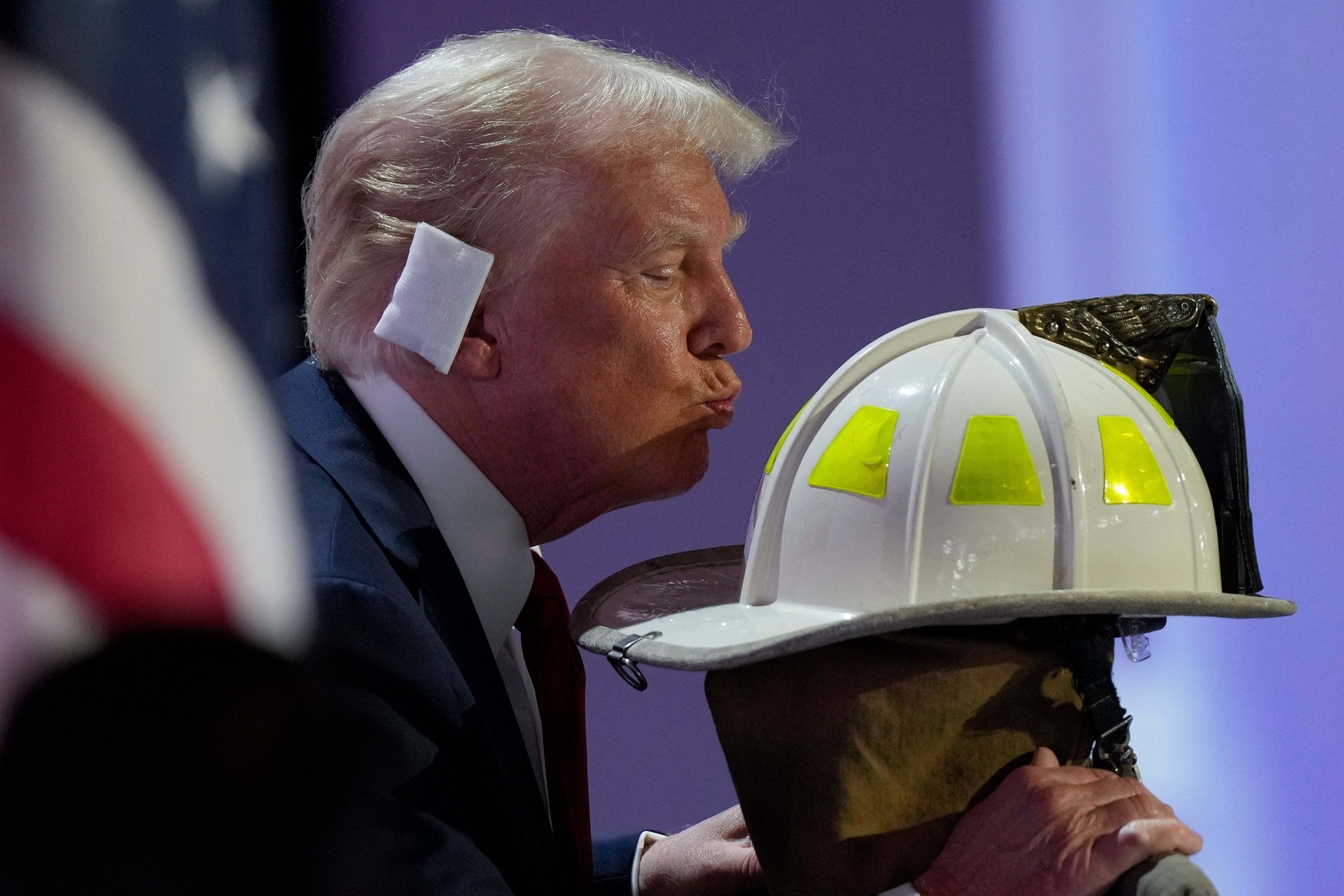 Donald Trump kisses the helmet of Corey Comperatore, the firefighter killed at his campaign rally on Saturday, during the final night of the RNC