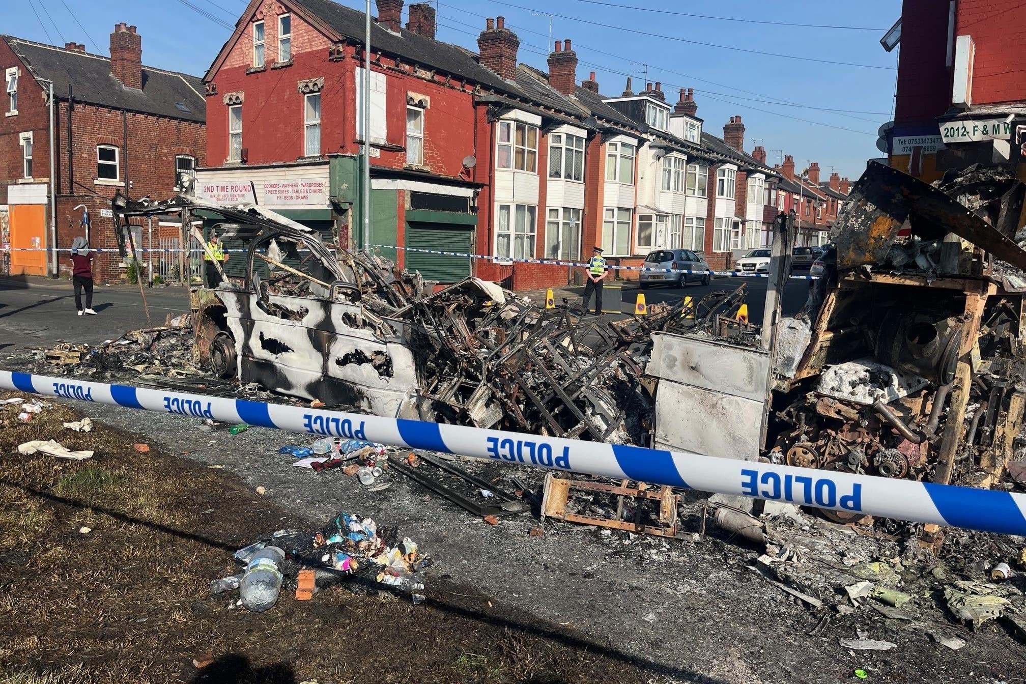 A burnt-out car in the Leeds suburb of Harehills after an outbreak of rioting left several vehicles ablaze and a police car overturned (Katie Dickinson/PA)