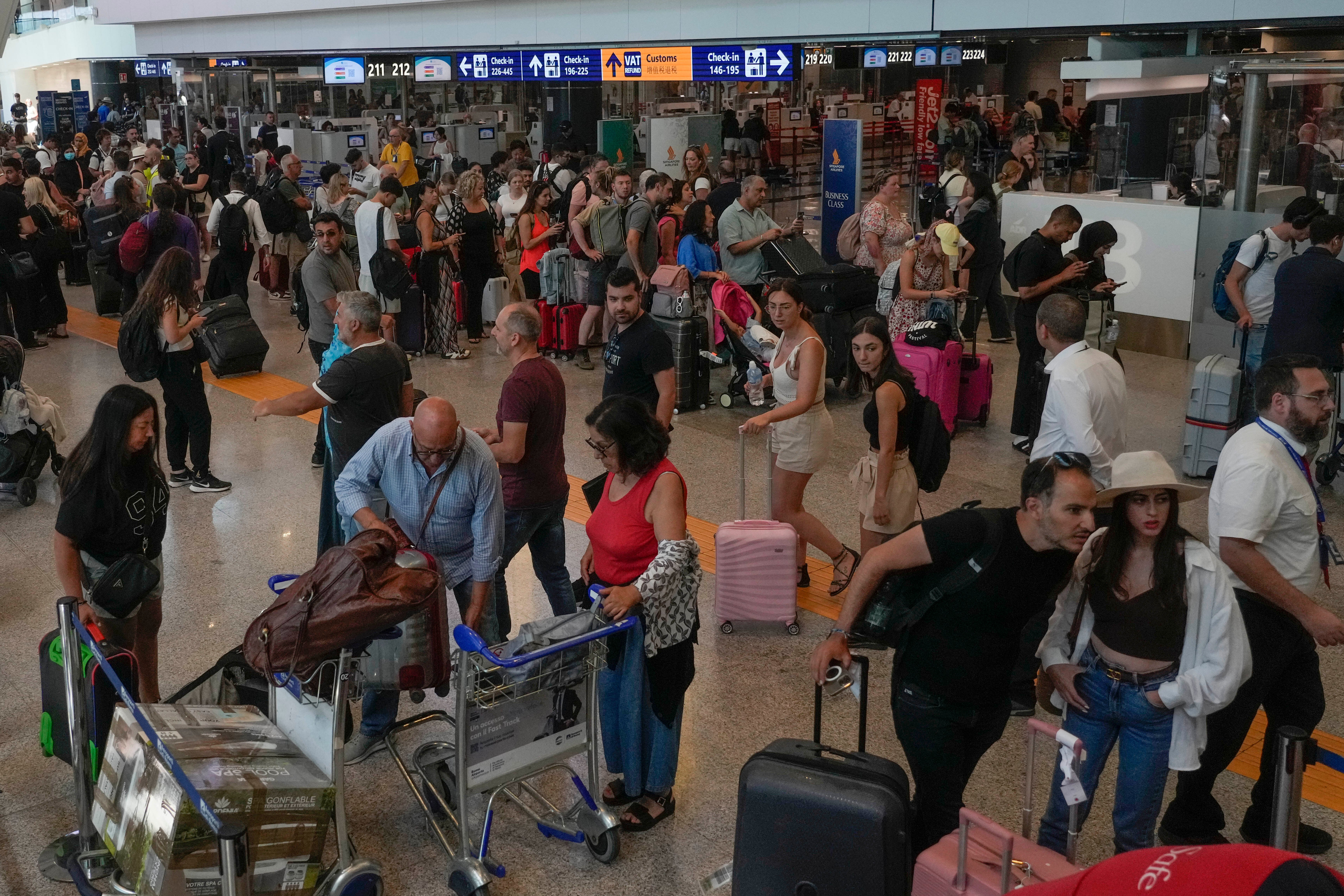 Passengers crowd the International flights departure terminal of Rome’s Fiumicino airport, Friday, July 19, 2024