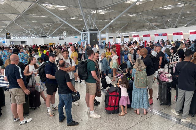 Passengers queueing at London Stansted Airport (Joe Giddens/PA)