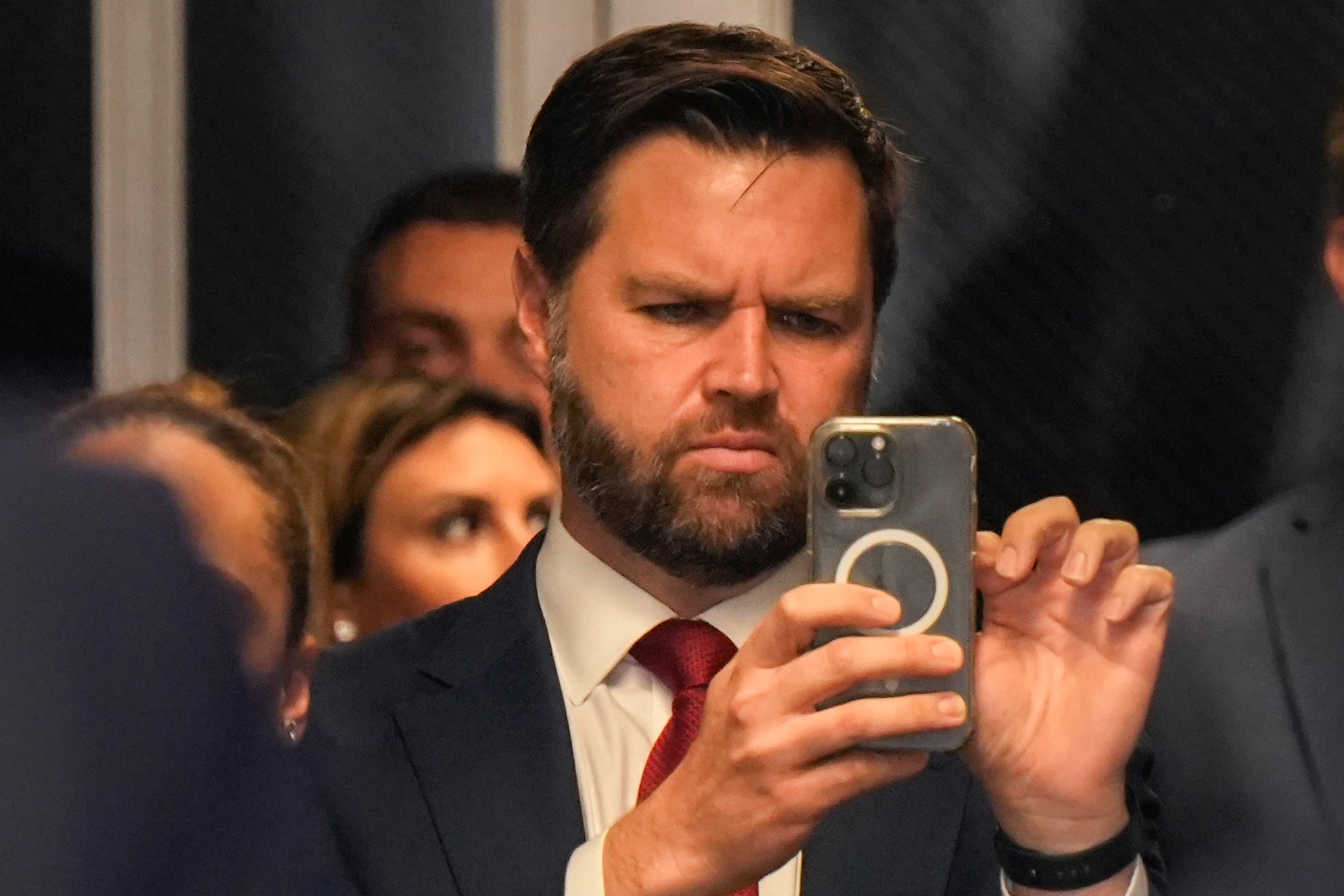 Republican vice presidential candidate J.D. Vance looks at his phone as former U.S. President Donald Trump speaks to the media with attorney Todd Blanche as he arrives for court during his trial for allegedly covering up hush money payments at Manhattan Criminal Court on May 13, 2024 in New York City.