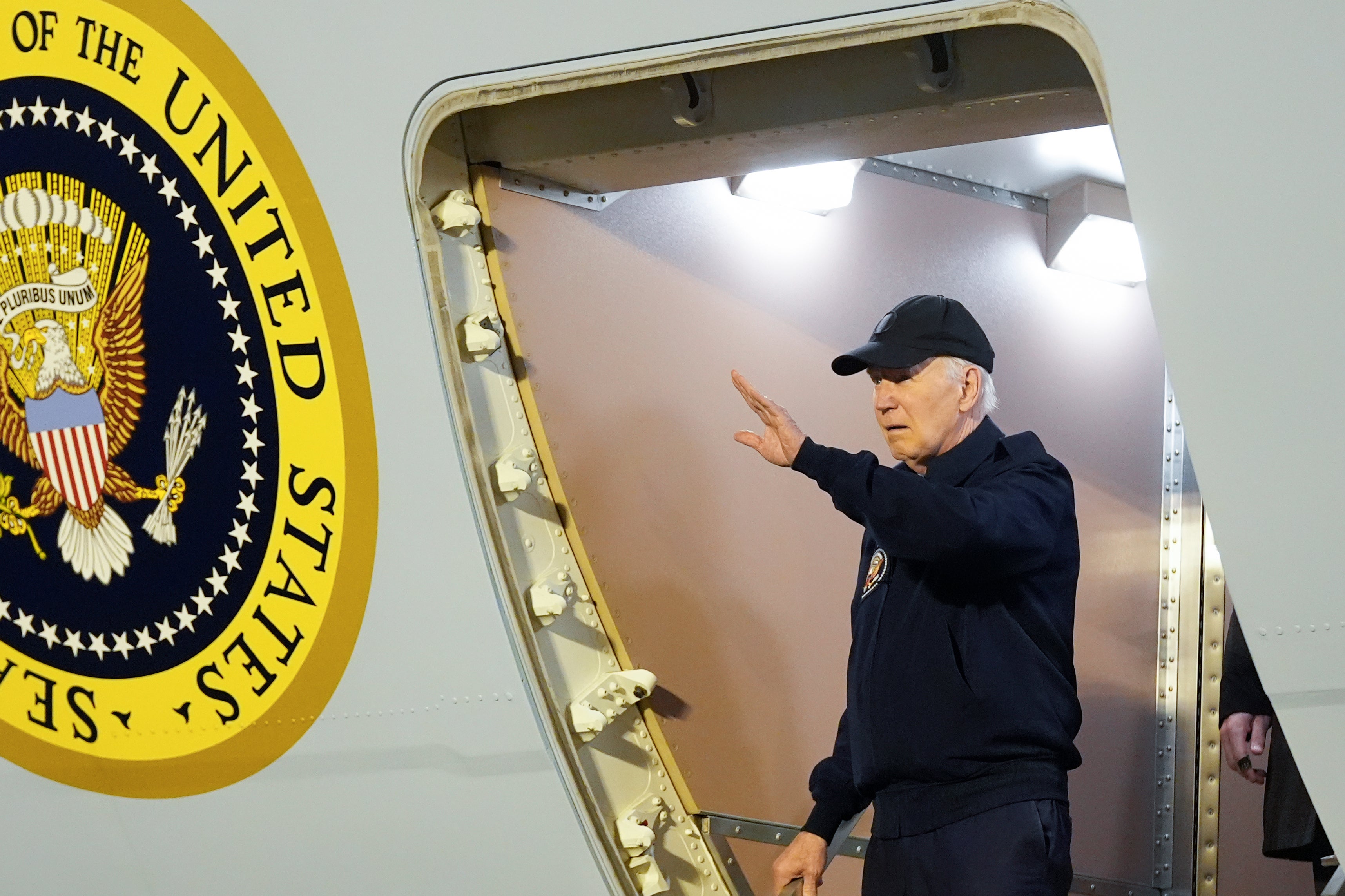 President Joe Biden waves as he walks down the steps of Air Force One in Delaware, Wednesday, July 17, 2024, after testing positive for Covid