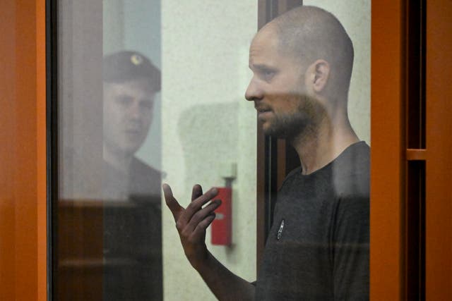 <p>US journalist Evan Gershkovich, accused of espionage, gestures inside a glass defendants' cage during the verdict announcement at the Sverdlovsk Regional Court in Yekaterinburg on July 19, 2024</p>