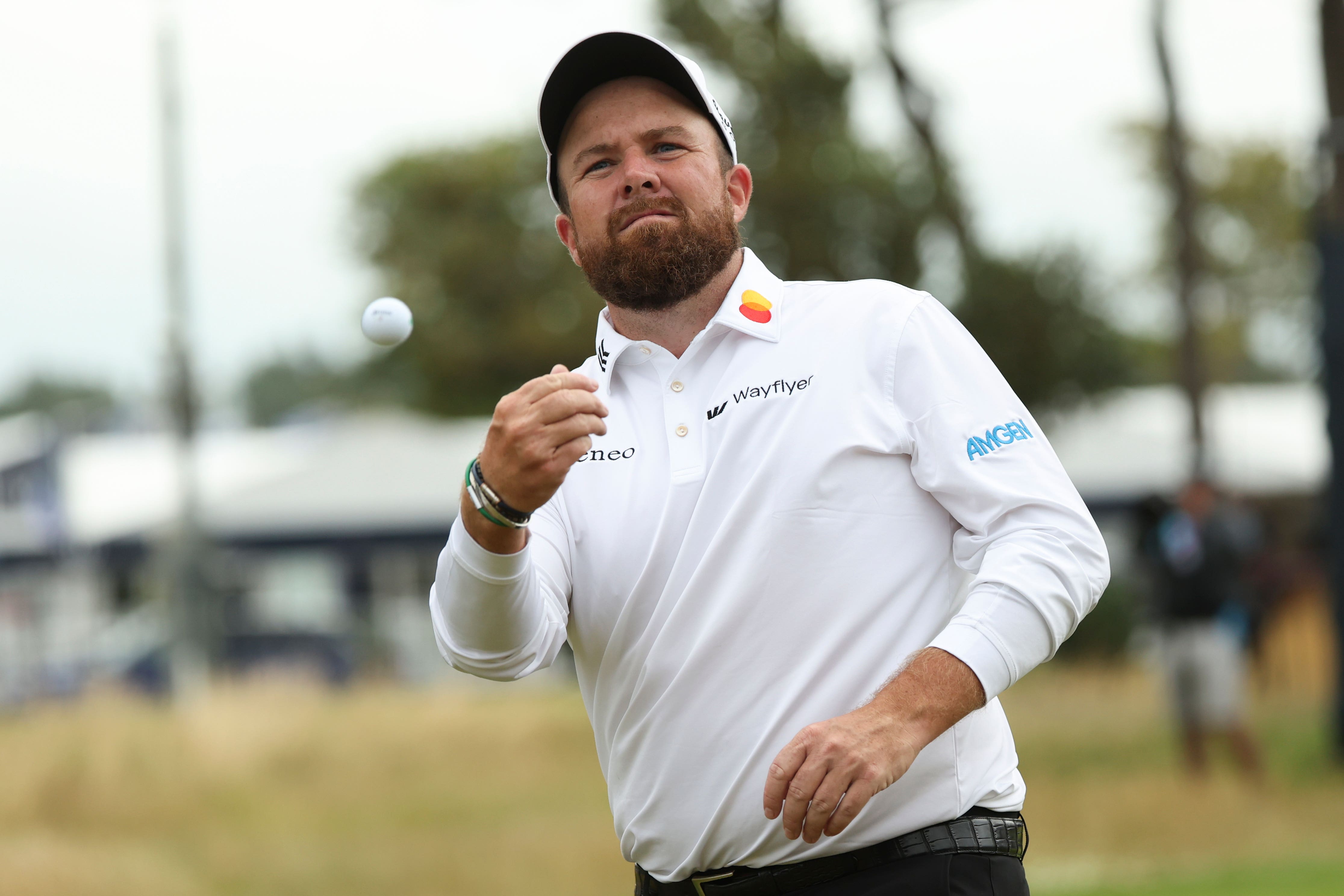 Shane Lowry melempar bola ke tribun penonton setelah memimpin dua pukulan di titik tengah Kejuaraan Terbuka ke-152.(Scott Heppell/Associated Press)