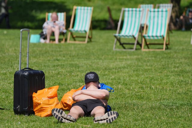 <p>A sunbather enjoys the hot weather at Green Park in central London (PA)</p>