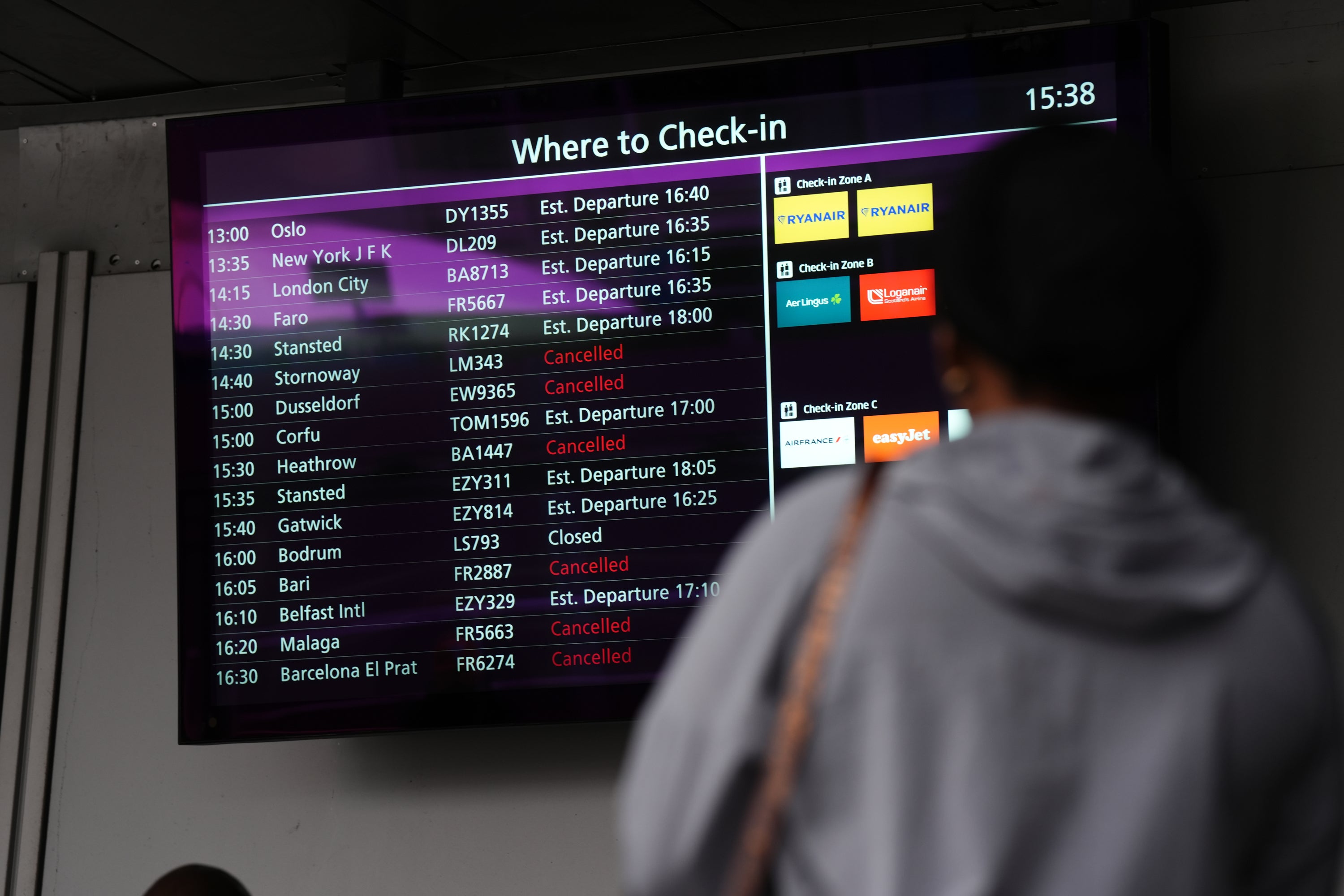 A person views a check-in display at Edinburgh Airport (Andrew Milligan/PA)