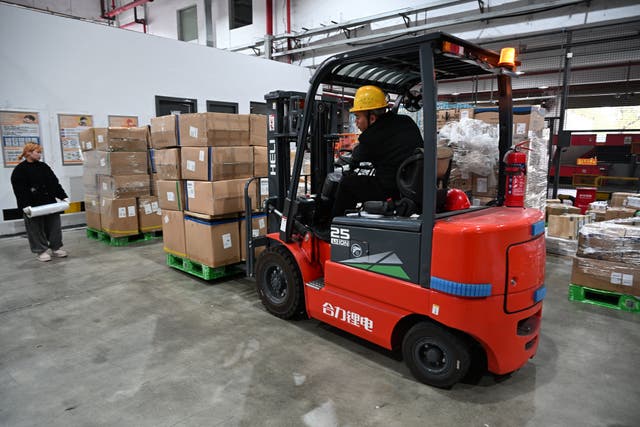 <p>Workers transport export-bound cargo at a logistics centre in Shanghai in January </p>