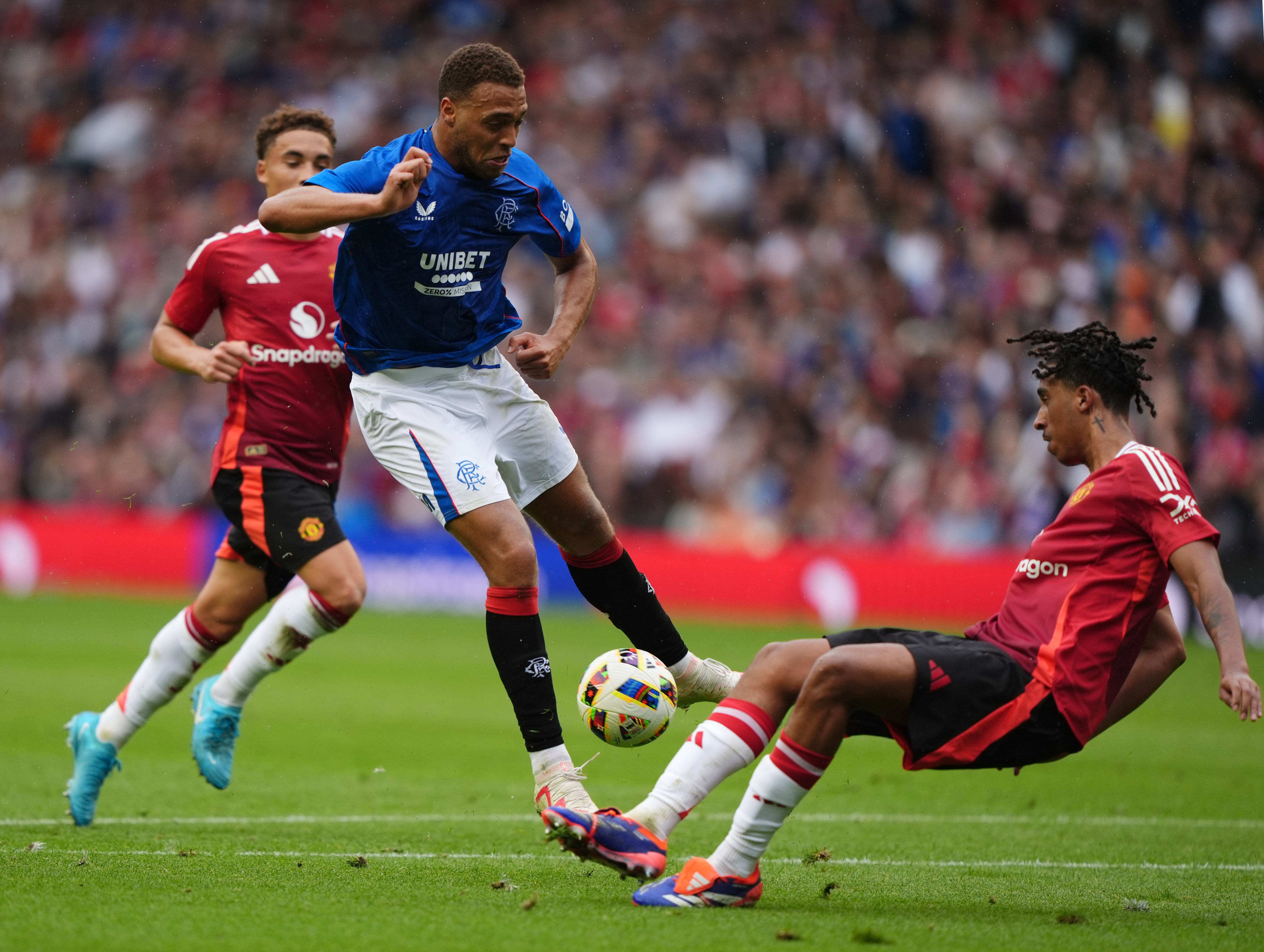 Rangers’ Cyriel Dessers (centre) has his shot blocked by Leny Yoro (Andrew Milligan/PA)