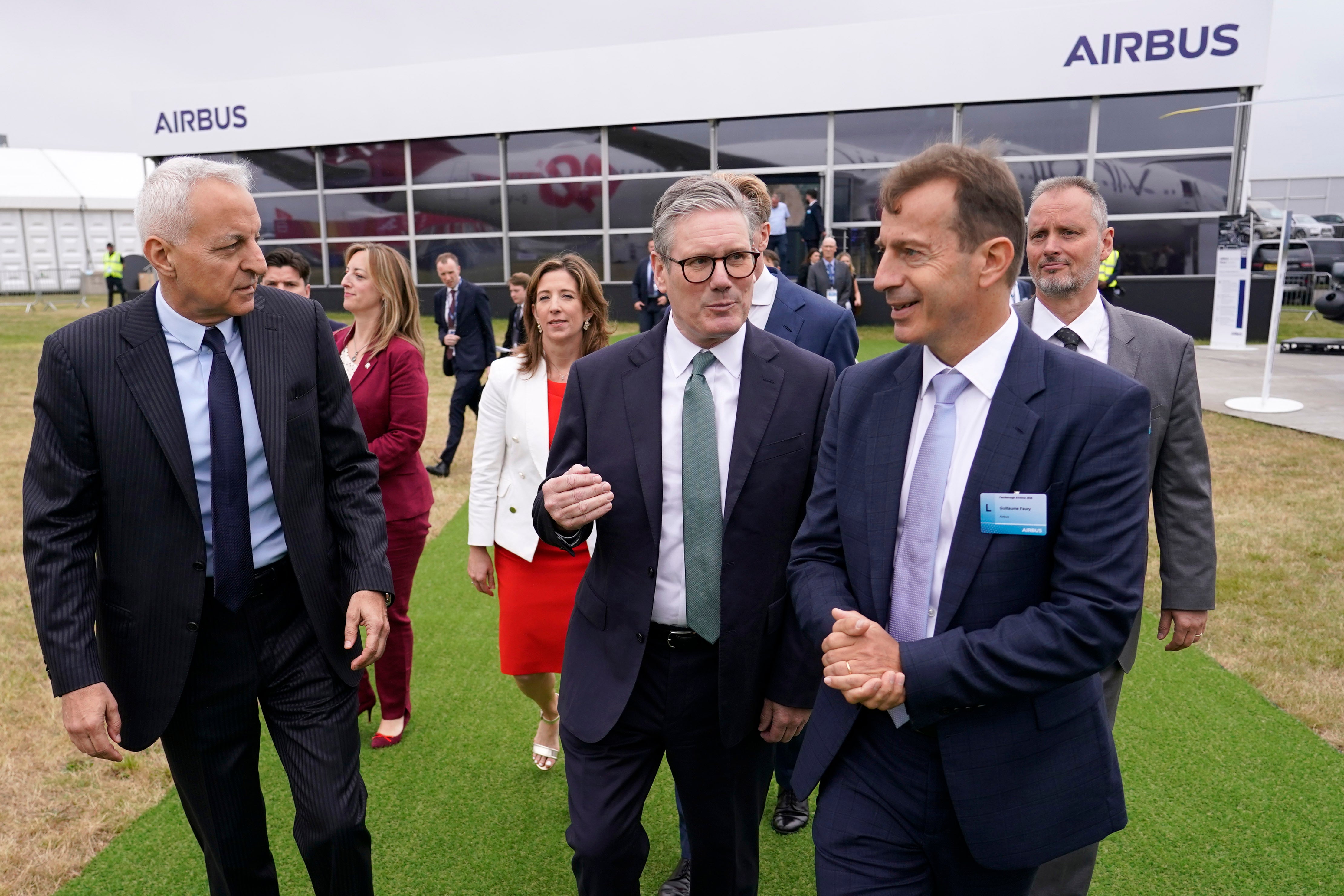 Britain's Prime Minister Keir Starmer, centre, speaks to Guillaume Faury, right, CEO of Airbus, as they arrive at the Farnborough International Airshow in Farnborough, England, Monday, July 22, 2024
