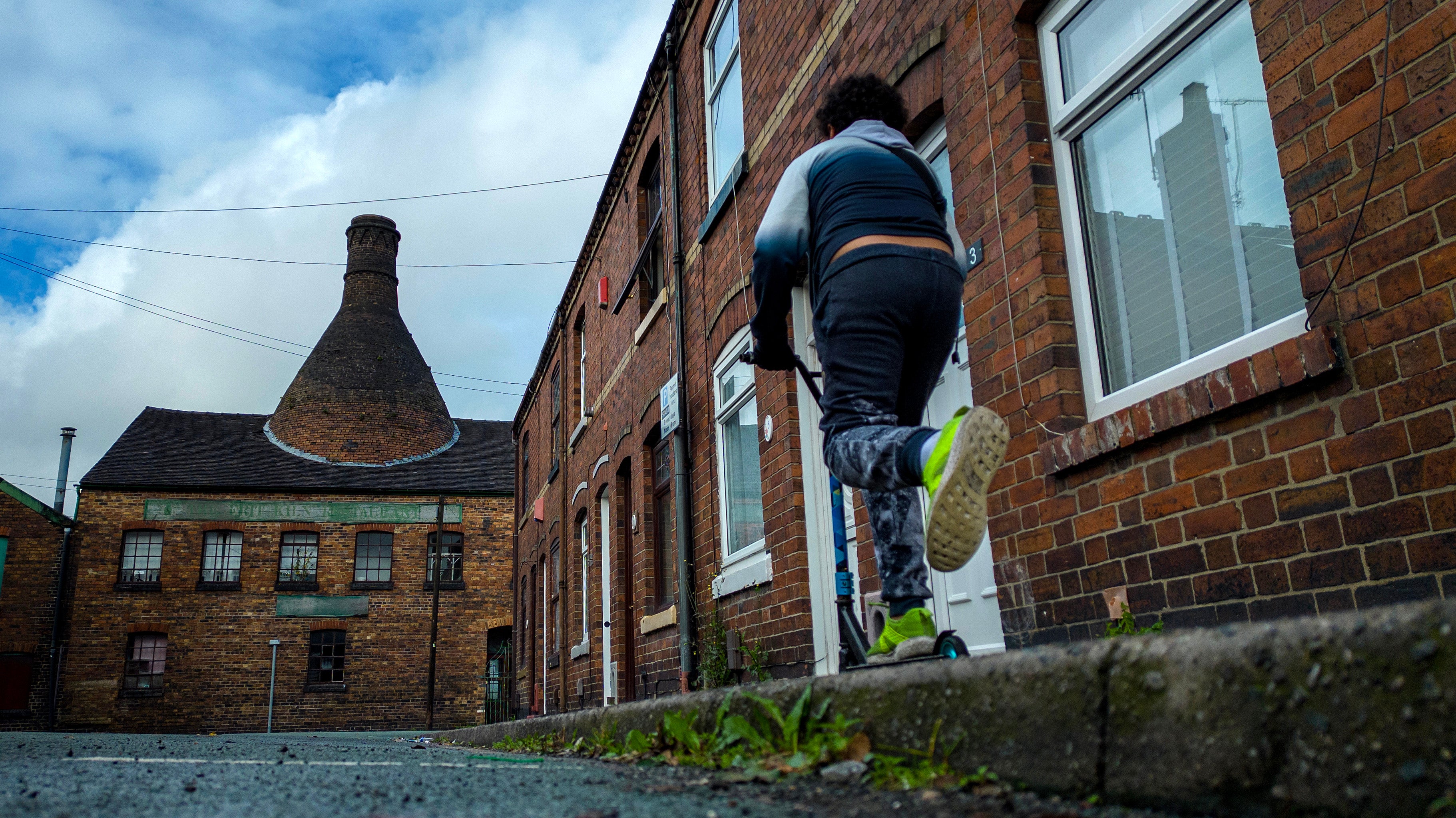 A boy plays in the street near the Heron Cross pottery kiln in Stoke on Trent, England. 1.6 million children were affected by the two-child benefit cap last year, government figures show.