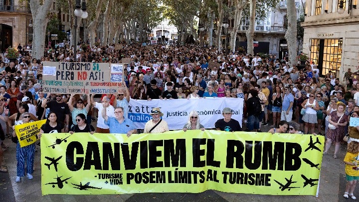 Protesters hold a banner which reads as "Let's change course" as they take part in a demonstration against overtourism and housing prices on the island of Mallorca in Palma de Mallorca on July 21, 2024