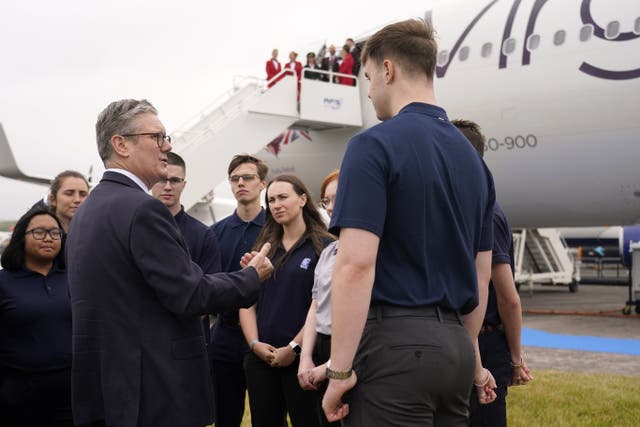 Prime Minister Sir Keir Starmer speaks to employees, as he arrives at the Farnborough International Airshow in Hampshire (Alberto Pezzali/PA)