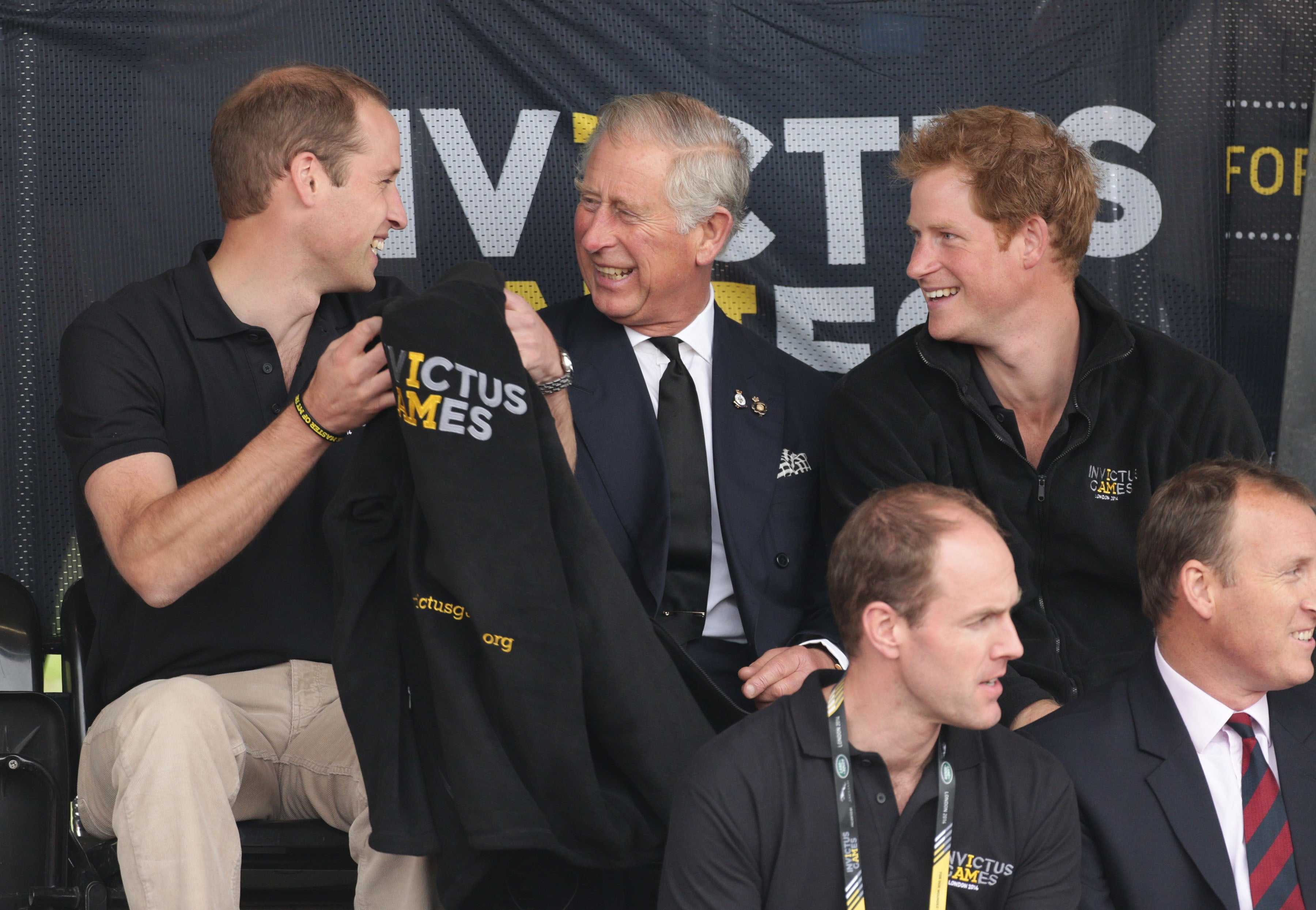 William, Charles and Harry share a joke as they watch the athletics at the Invictus Games in 2014 (Yui Mok/PA)