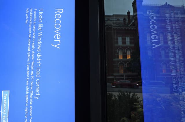 <p>A blue Windows error message caused by the CrowdStrike software update is displayed on a screen in a bus shelter</p>