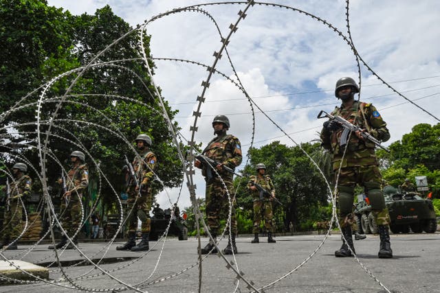 <p>Bangladeshi soldiers stand guard near the parliament house amid a curfew following clashes between police and protesters</p>