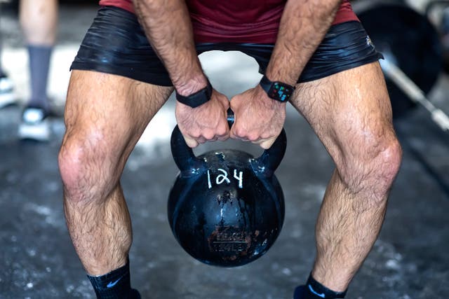 <p>John Puccio lifts a kettlebell during a workout at the Strength Factory gym on 2 July 2022 in Baldwin, New York</p>