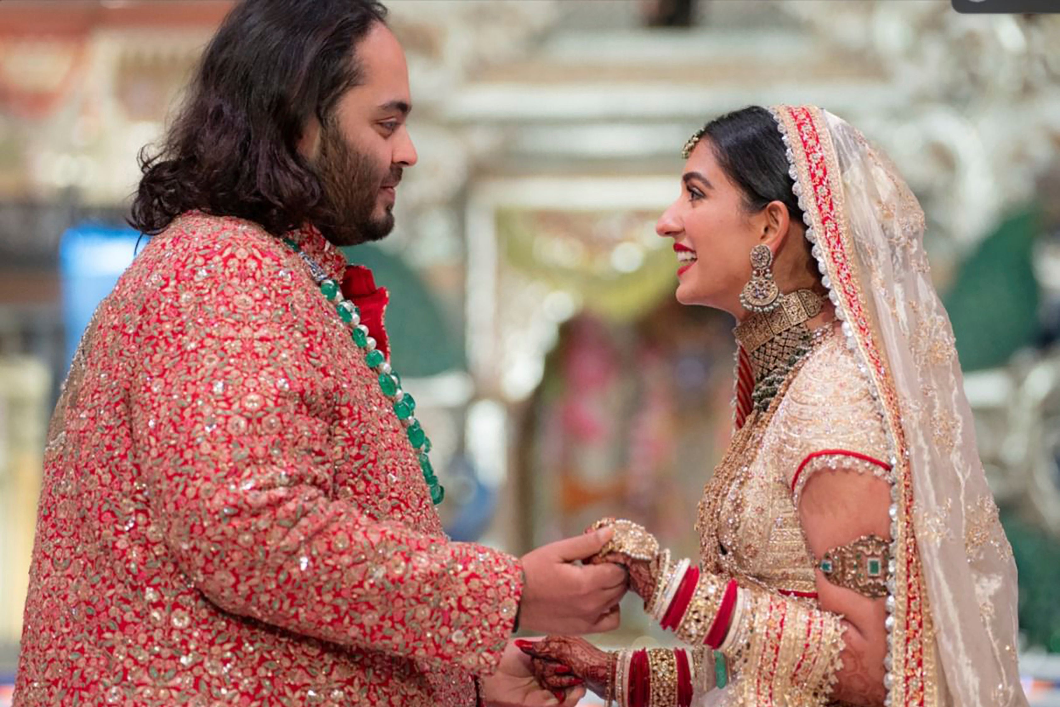 The bride made her entrance on an electric wooden boat before the couple exchanged their vows under a large altar with white domes.