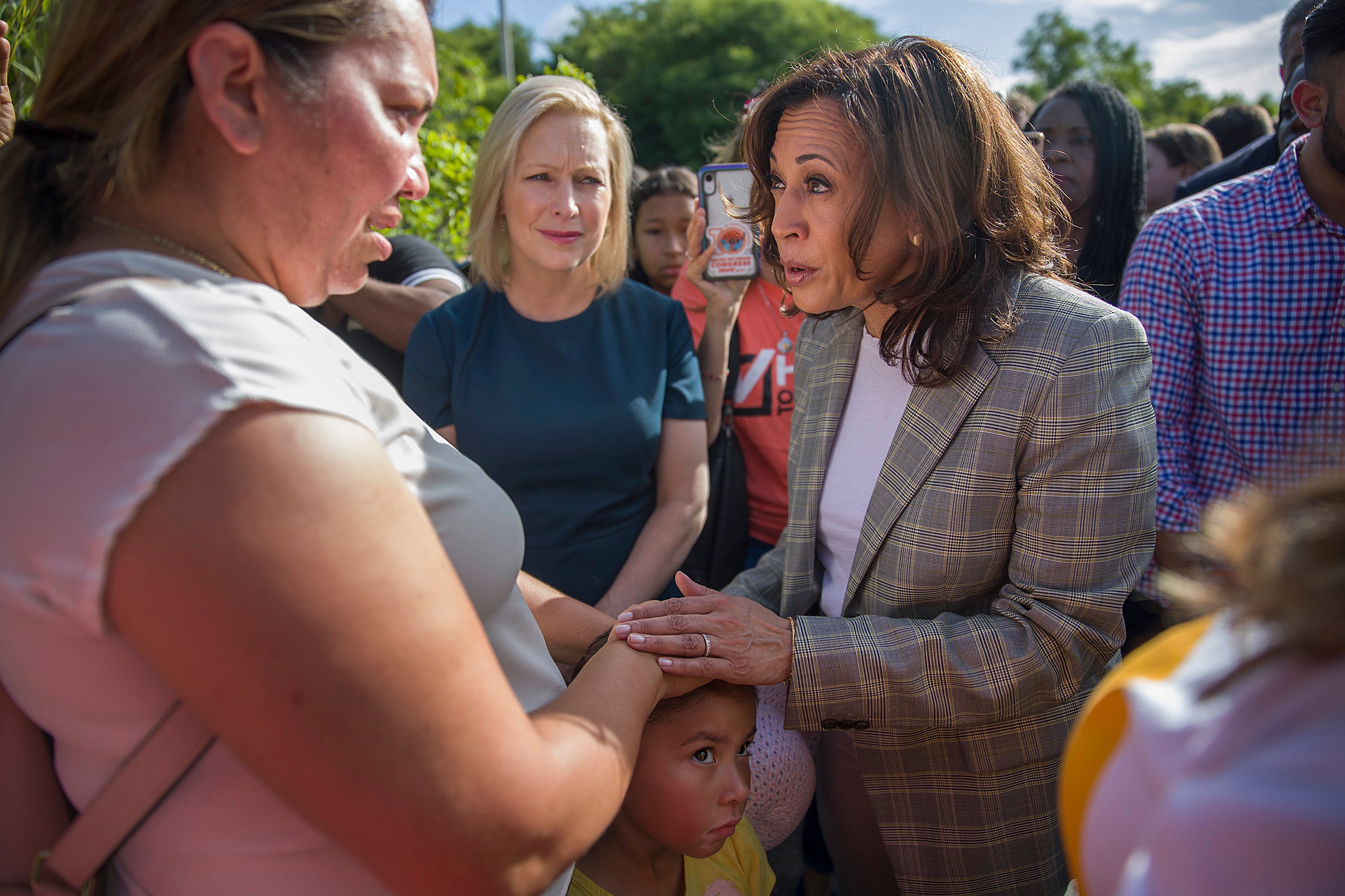 Democratic presidential candidates, Senator Kamala Harris speaks with Lili Montalban and her daughter Roxanna Gozzer, as they visit the outside of a detention center for migrant children on June 28, 2019 in Homestead, Florida