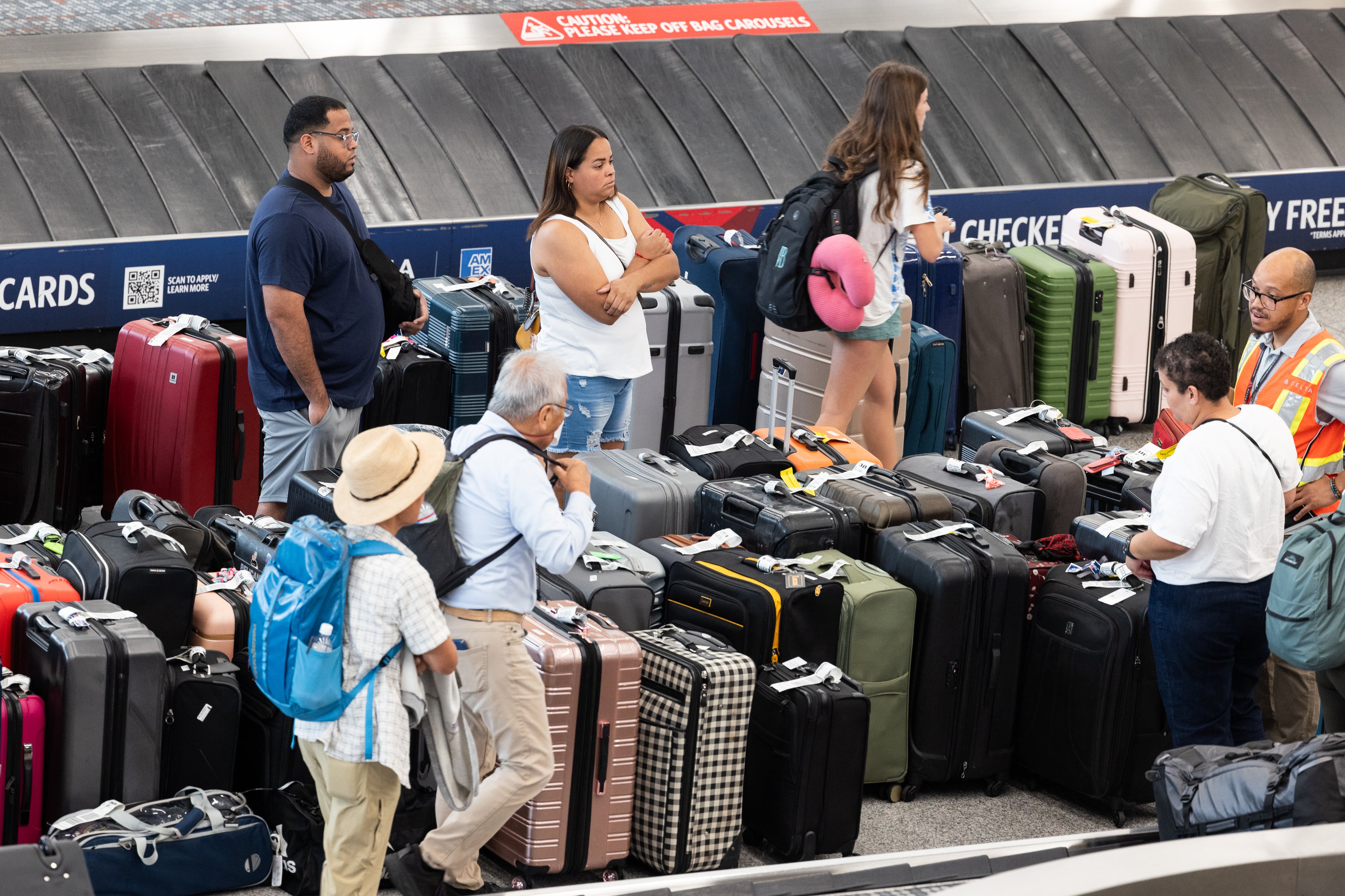 Passengers wait among suitcases at Hartsfield-Jackson Atlanta International Airport as Delta Air Lines experiences major delays to a faulty CrowdStrike software update