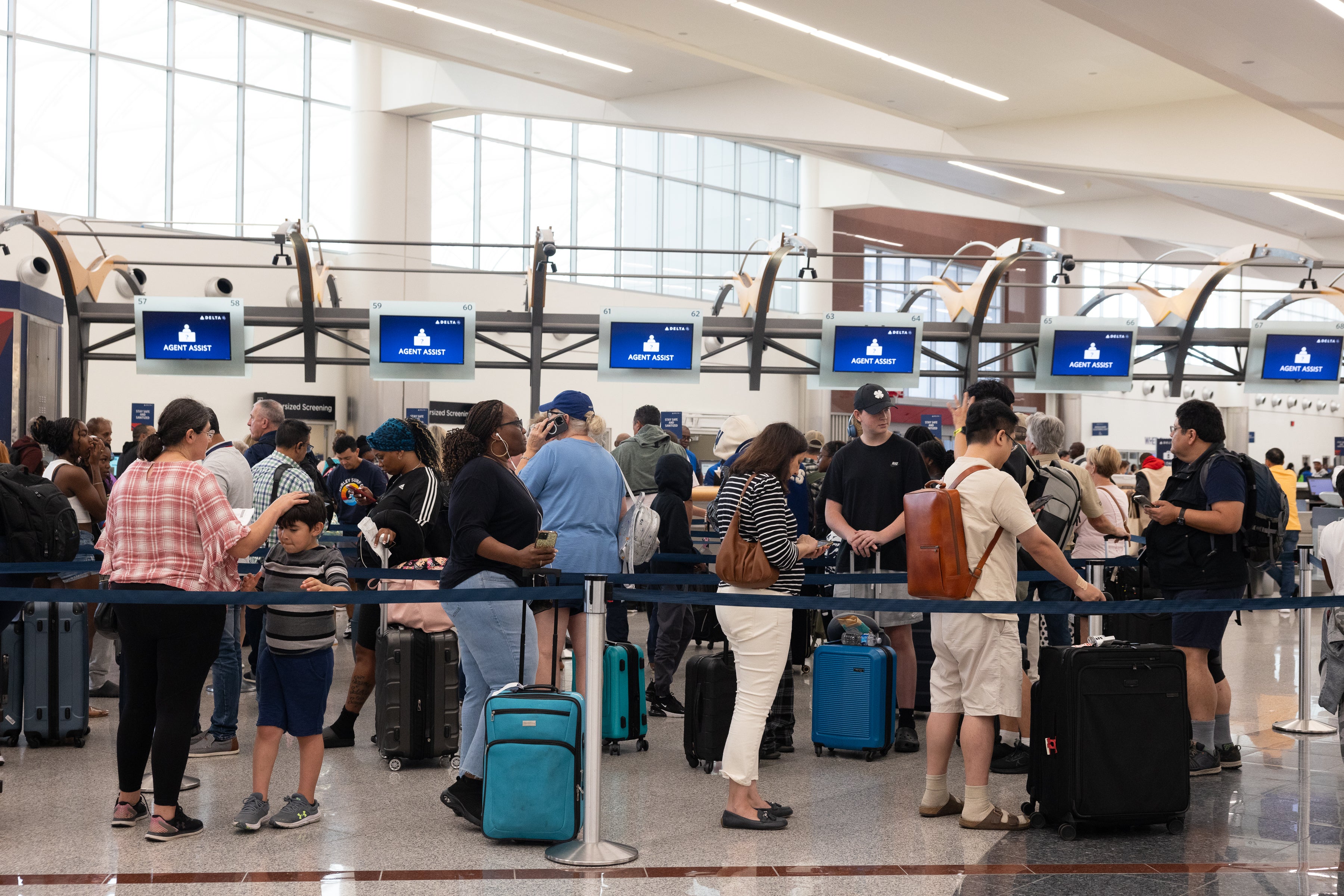 Delta passengers line up to talk with ticketing agents after canceled and delayed flights at Hartsfield-Jackson Atlanta International Airport on July 22. Delta is now looking to sue CrowdSource over IT failures that left travelers stuck at airports.