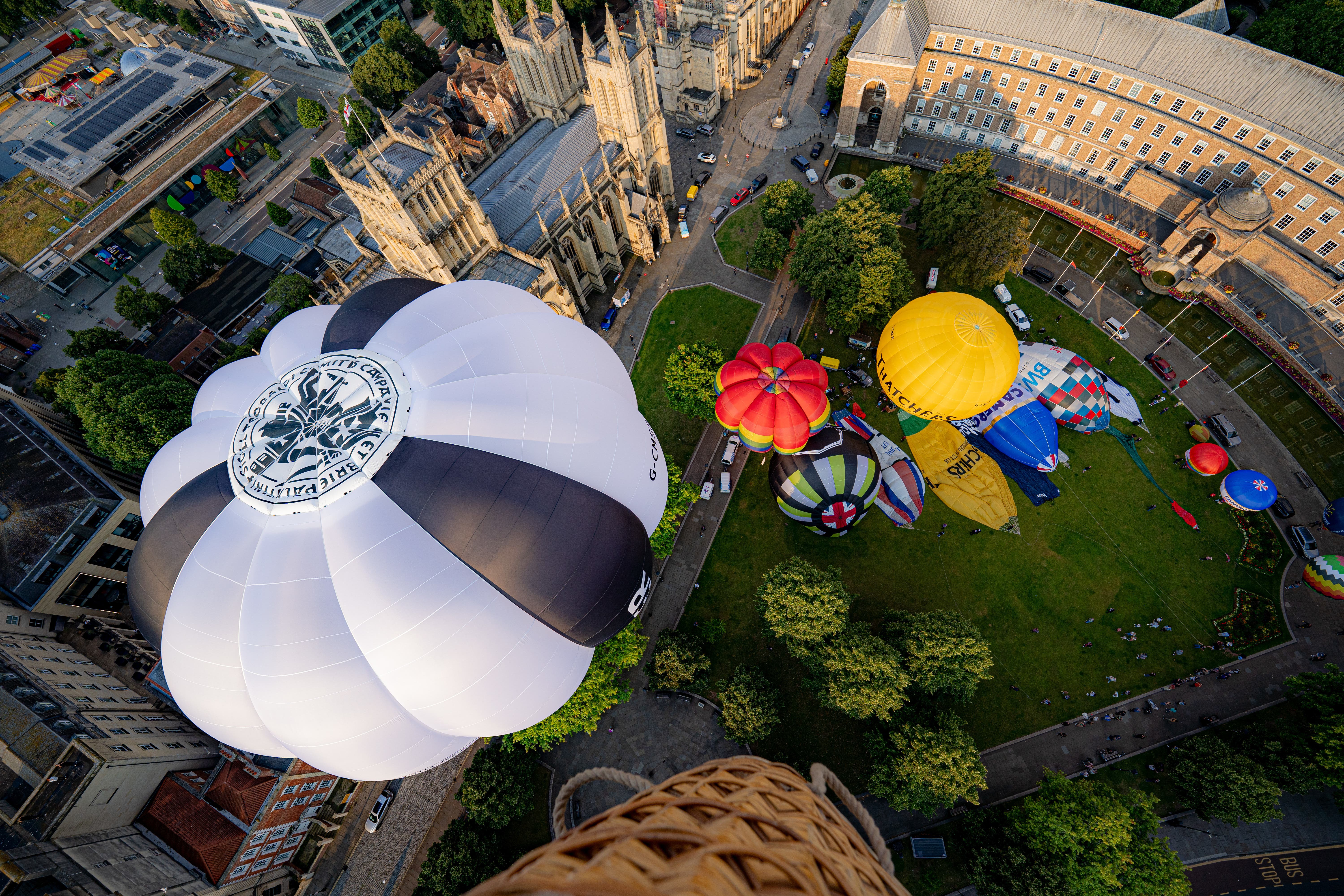 Hot air balloons lift off beside Bristol Cathedral (Ben Birchall/PA)