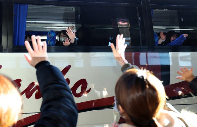 <p>Junior high school students wave from a bus as they leave their families on a group evacuation in Wajima, Ishikawa prefecture after a major 7.5 magnitude earthquake</p>