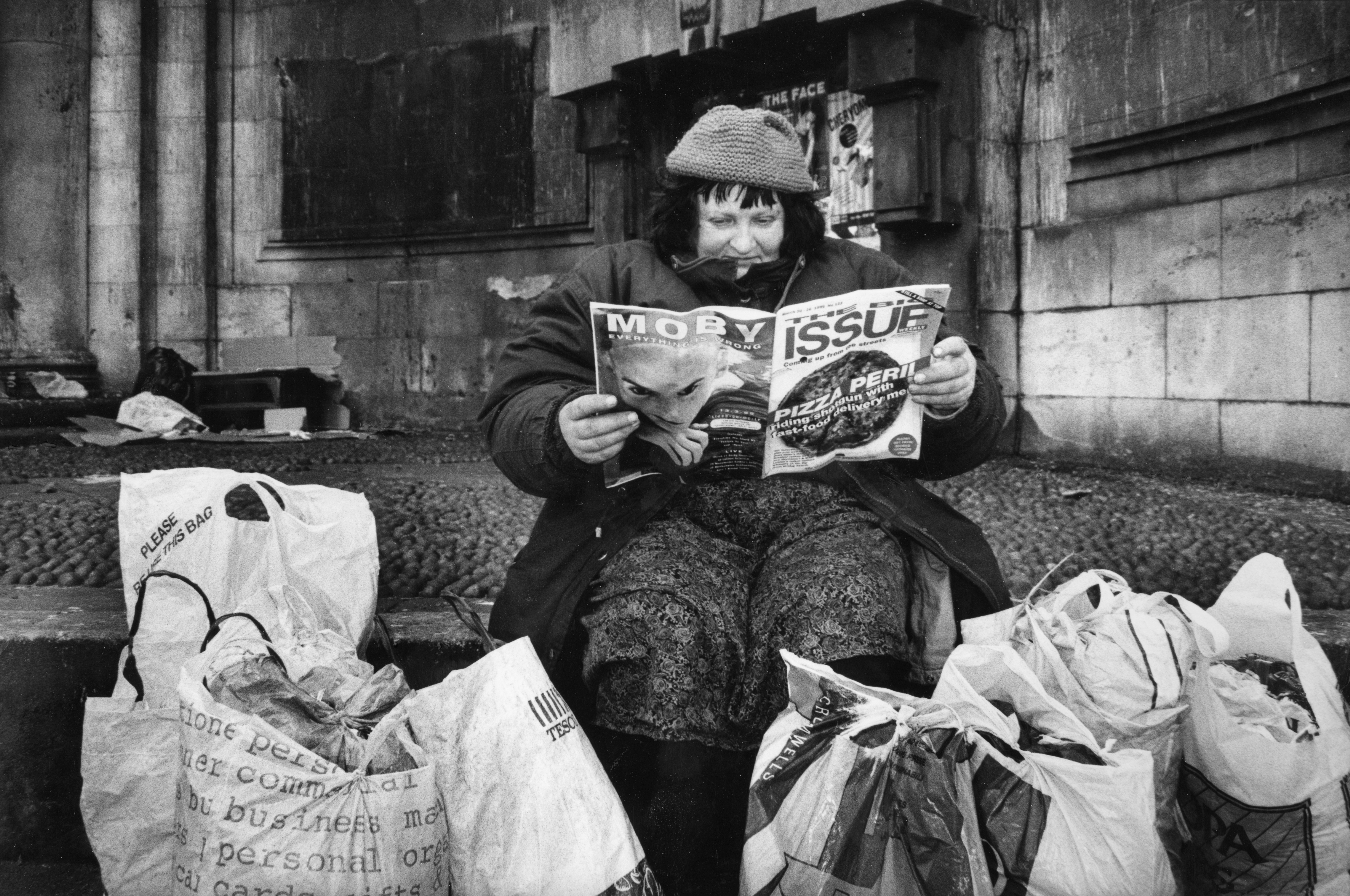 Mary surrounded by her belongings, reading ‘The Big Issue’, in Kingsway, in 1995