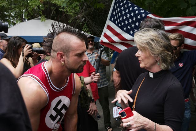 <p> Neelley Hicks, a Reverend in the United Methodist Church tries to find out why a member of Neo-Nazi group Goyim Defense League has his point of view outside of the ‘Nashville Together’ event at the Bicentennial Park </p>