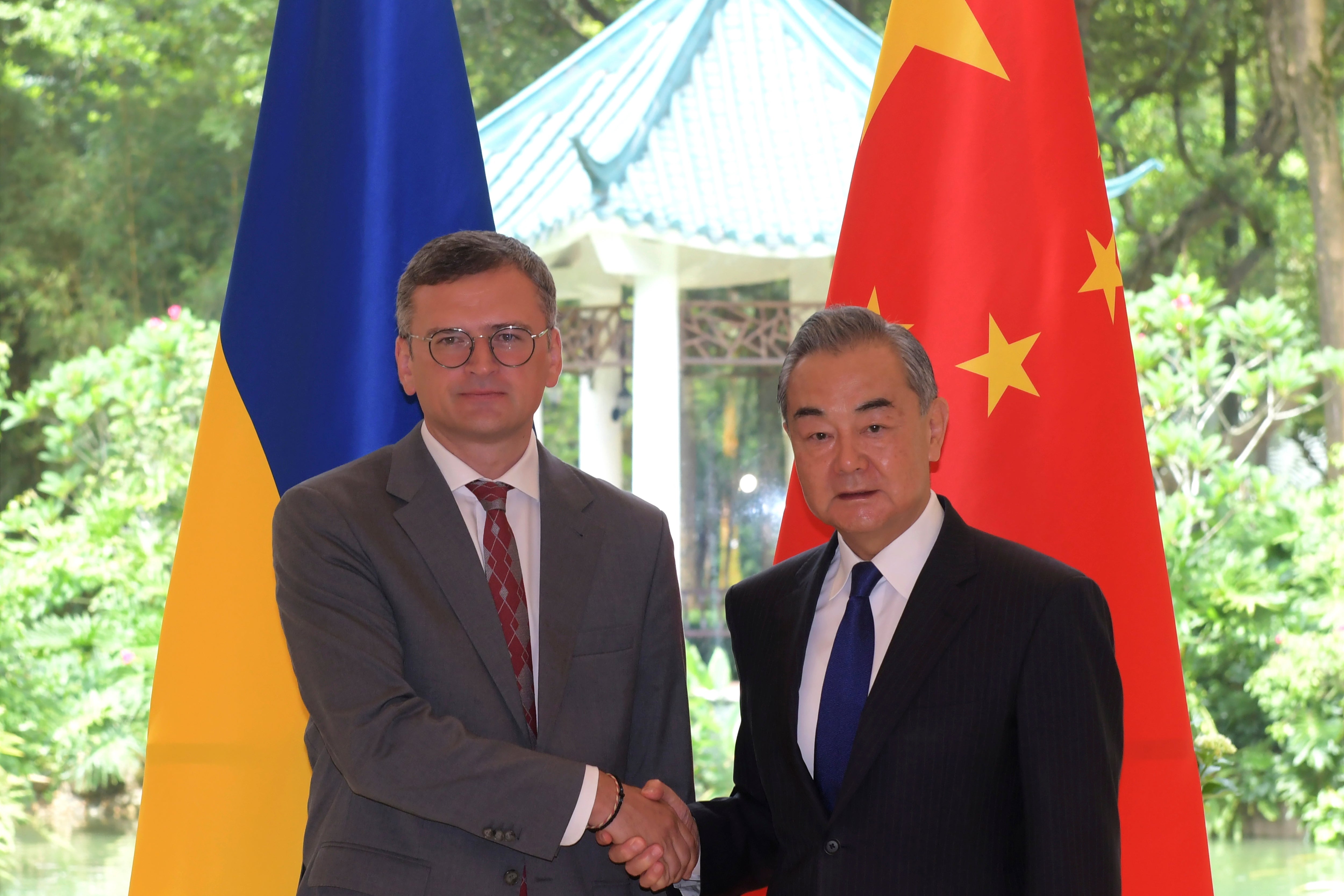 In this photo released by Xinhua News Agency, Ukraine's Foreign Ministry Dmytro Kuleba, left, poses for photos with China's Foreign Minister Wang Yi before a meeting in the southern Chinese city of Guangzhou