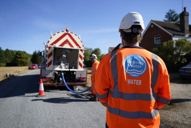 A worker from Thames Water delivering a temporary water supply (Andrew Matthews/PA)