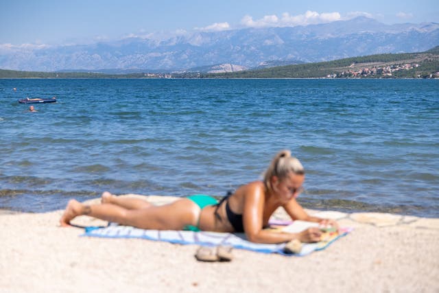 <p>A woman sunbathes at the beach next to the Karin sea in Gornji Karin, Croatia, July 23, 2024</p>
