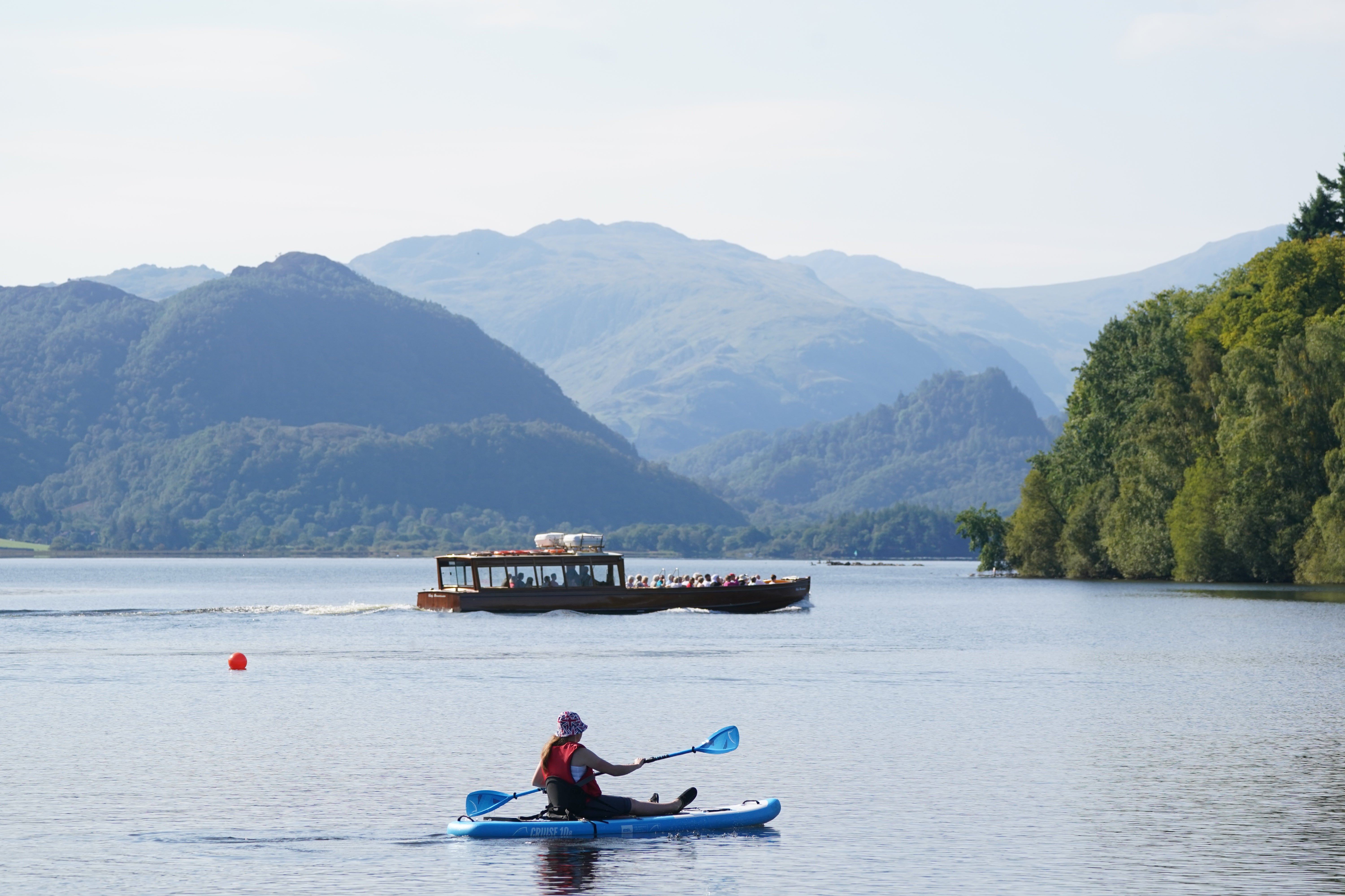 A paddle boarder goes out in the September sunshine (Owen Humphreys/PA)