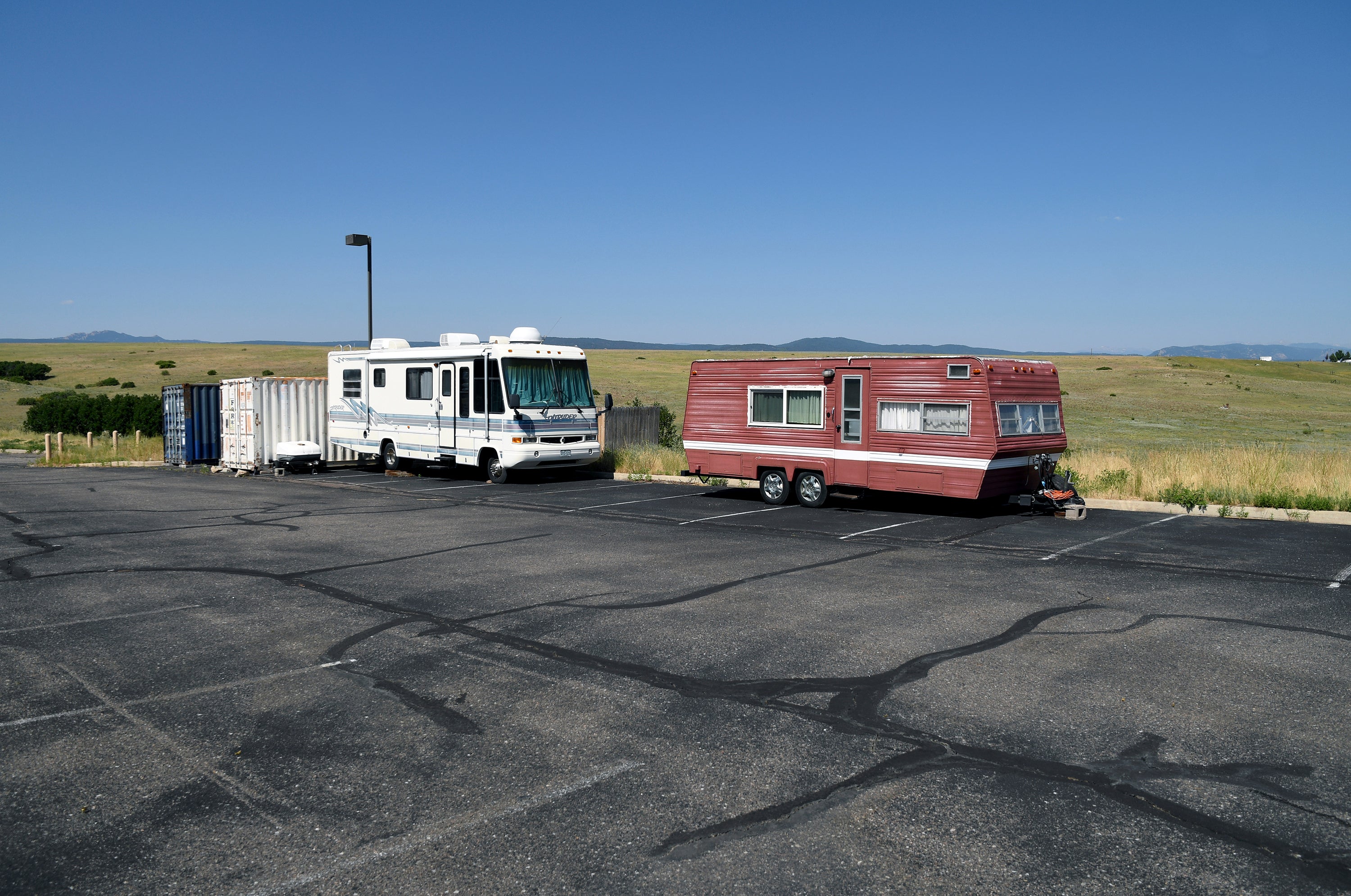 A recreational vehicle and camping trailer sit empty in The Rock church’s parking lot