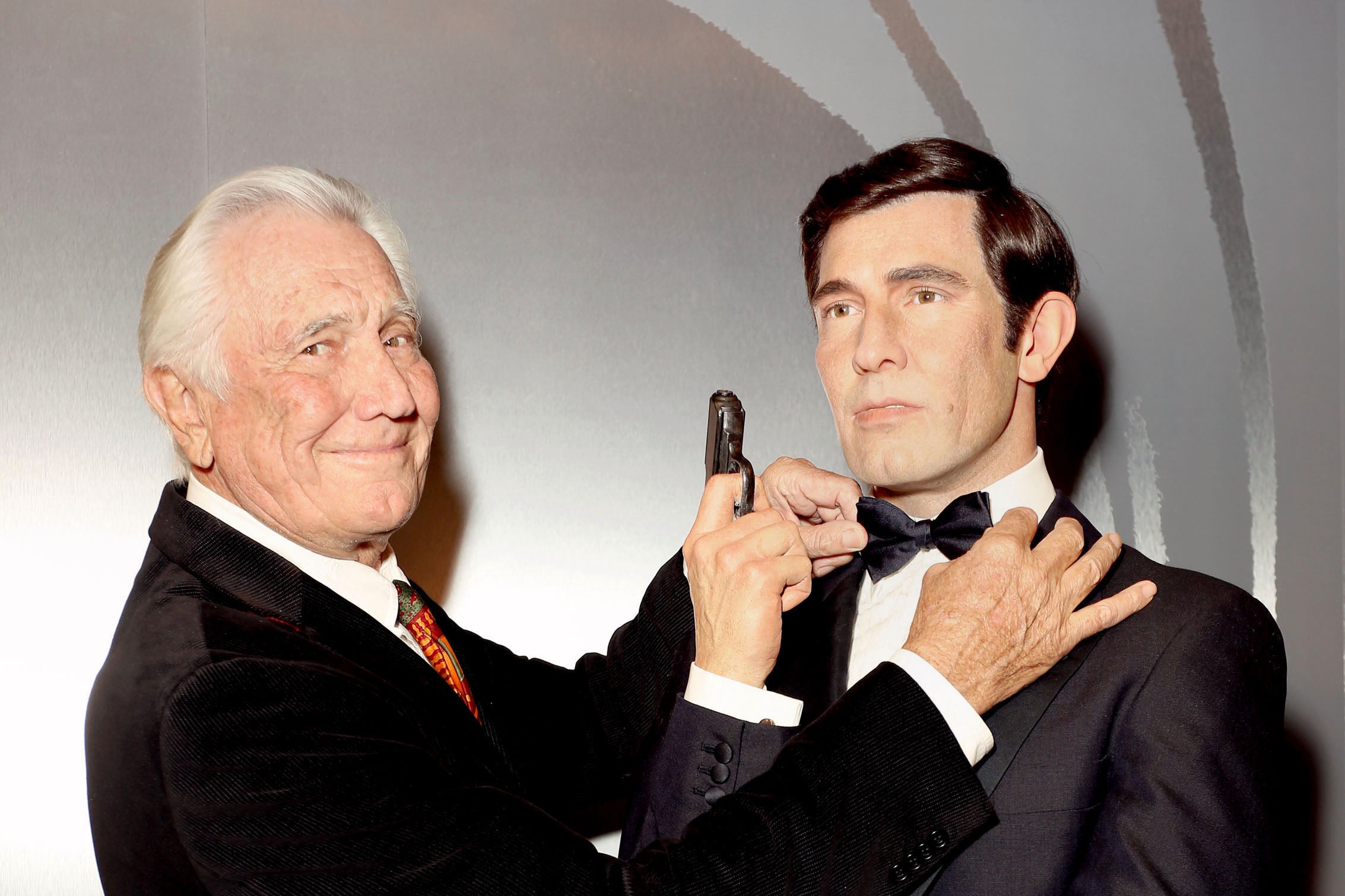 George Lazenby poses with his wax figure at Madame Tussauds in 2015