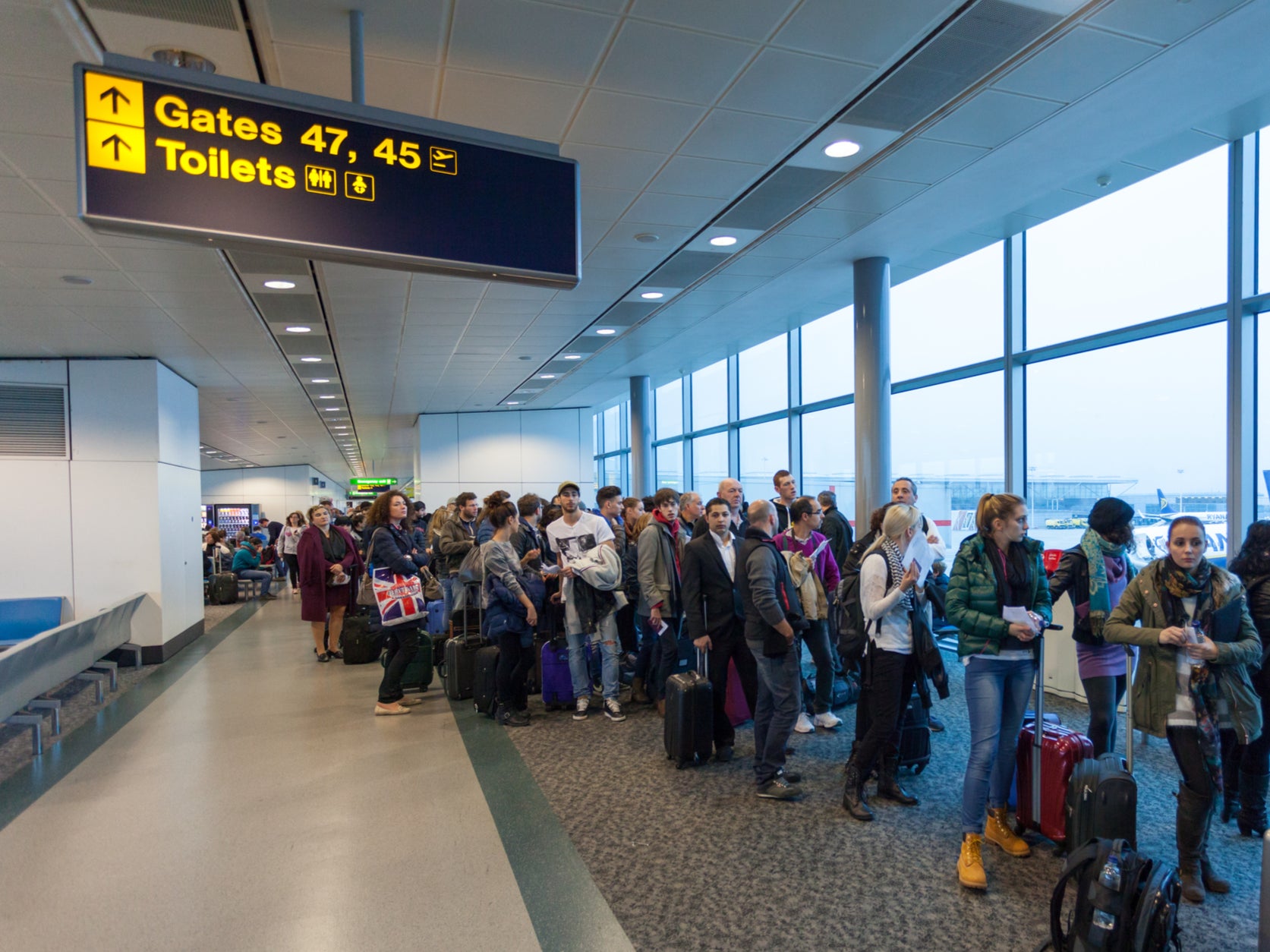 Air travellers waiting in queue for boarding at London Stansted Airpor