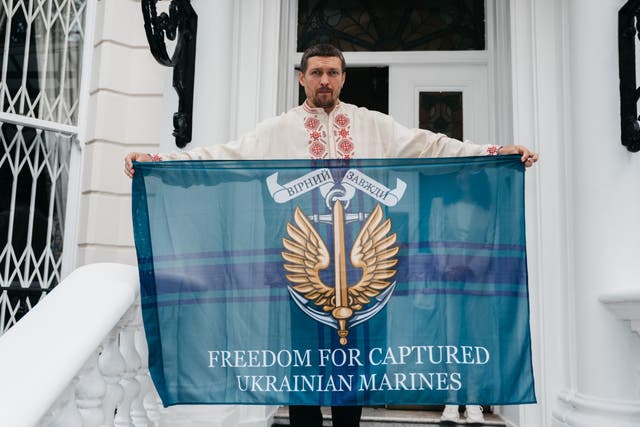 <p>Ukrainian heavyweight boxing champion Oleksandr Usyk holds a flag outside the Ukrainian embassy in London calling for the release of captured Ukrainian marines </p>