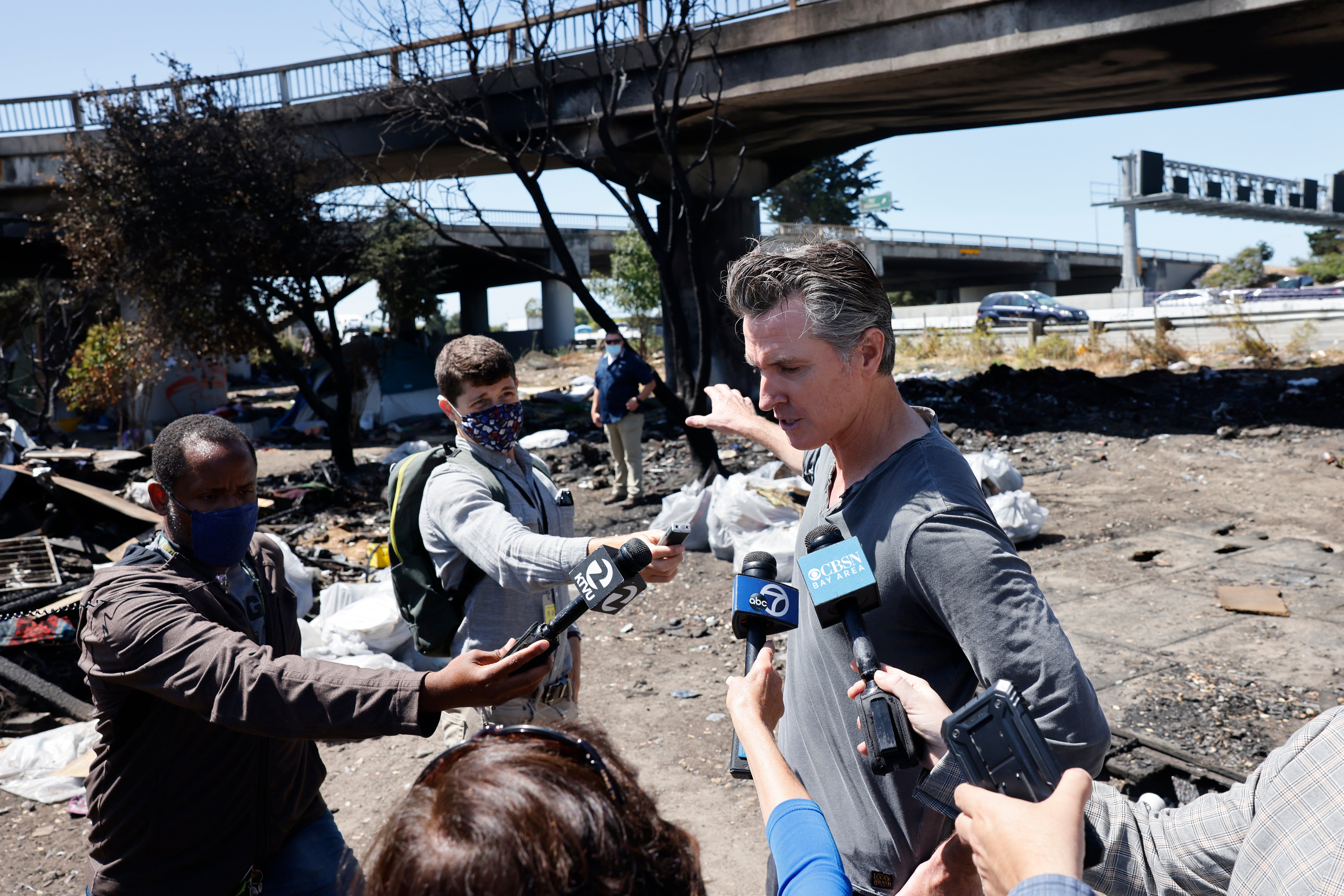 California Governor Gavin Newsom speaks with media at a long-standing homeless encampment along Highway 80 on August 9, 2021 in Berkeley, California.