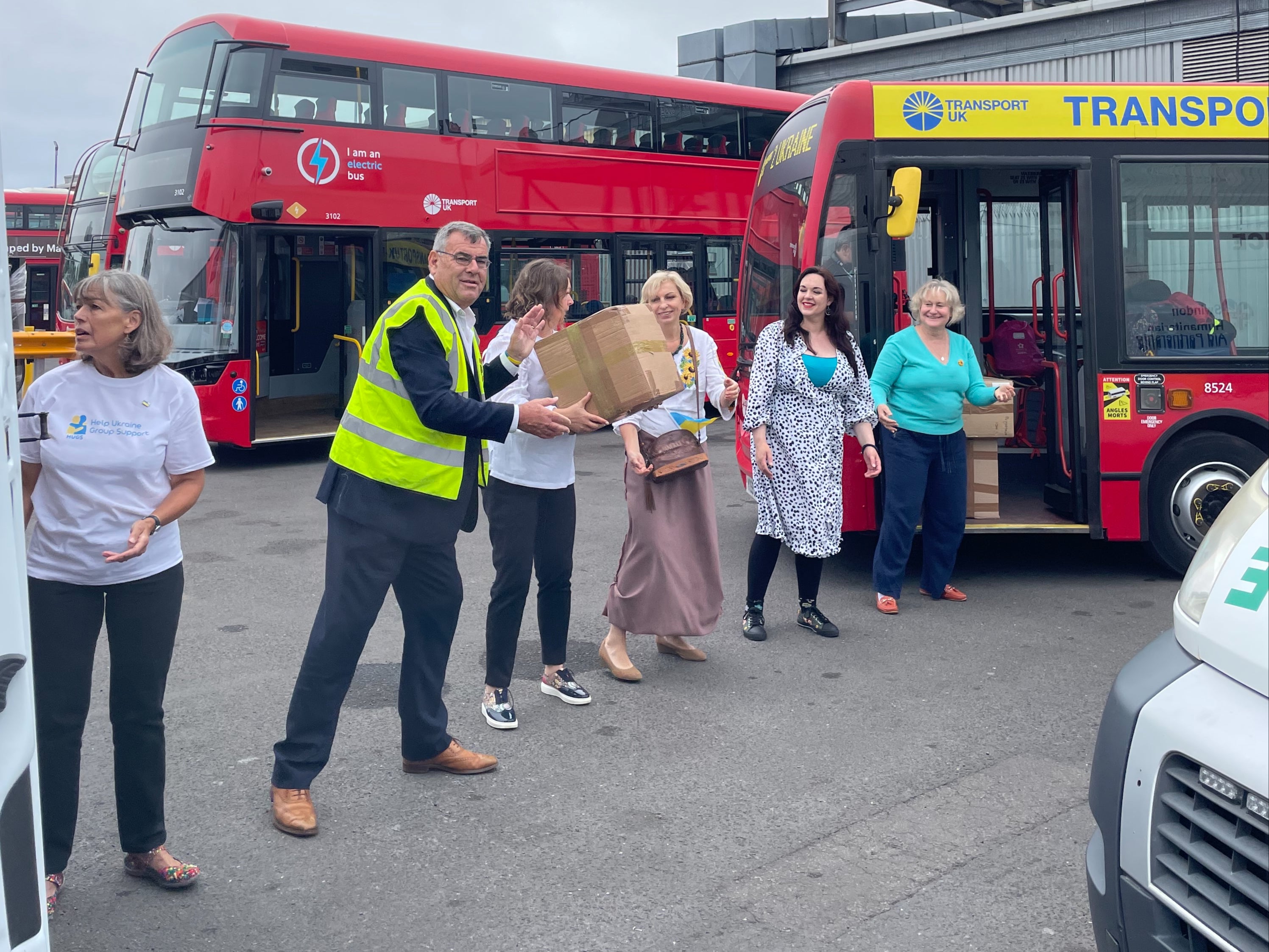 Mike Bowden, chair of SHAP, (2L) works with others Swindon aid workers to load up the London red bus with supplies for Ukraine