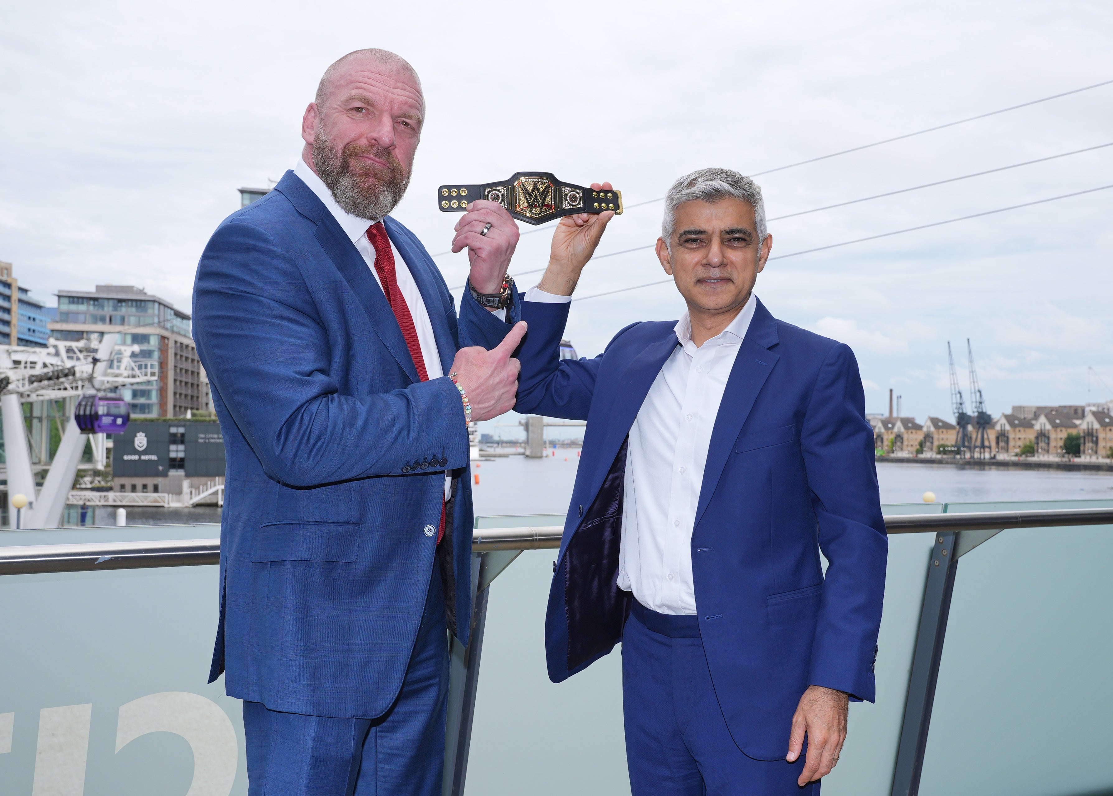 Mayor of London Sadiq Khan, right, holds aloft a gifted mini replica WWE Championship belt, with Paul ‘Triple H’ Levesque