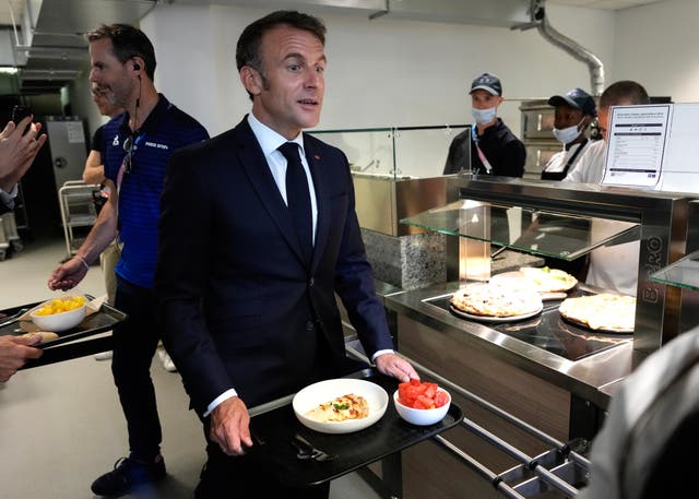 <p>Emmanuel Macron is served food in the Paris Olympic village</p>