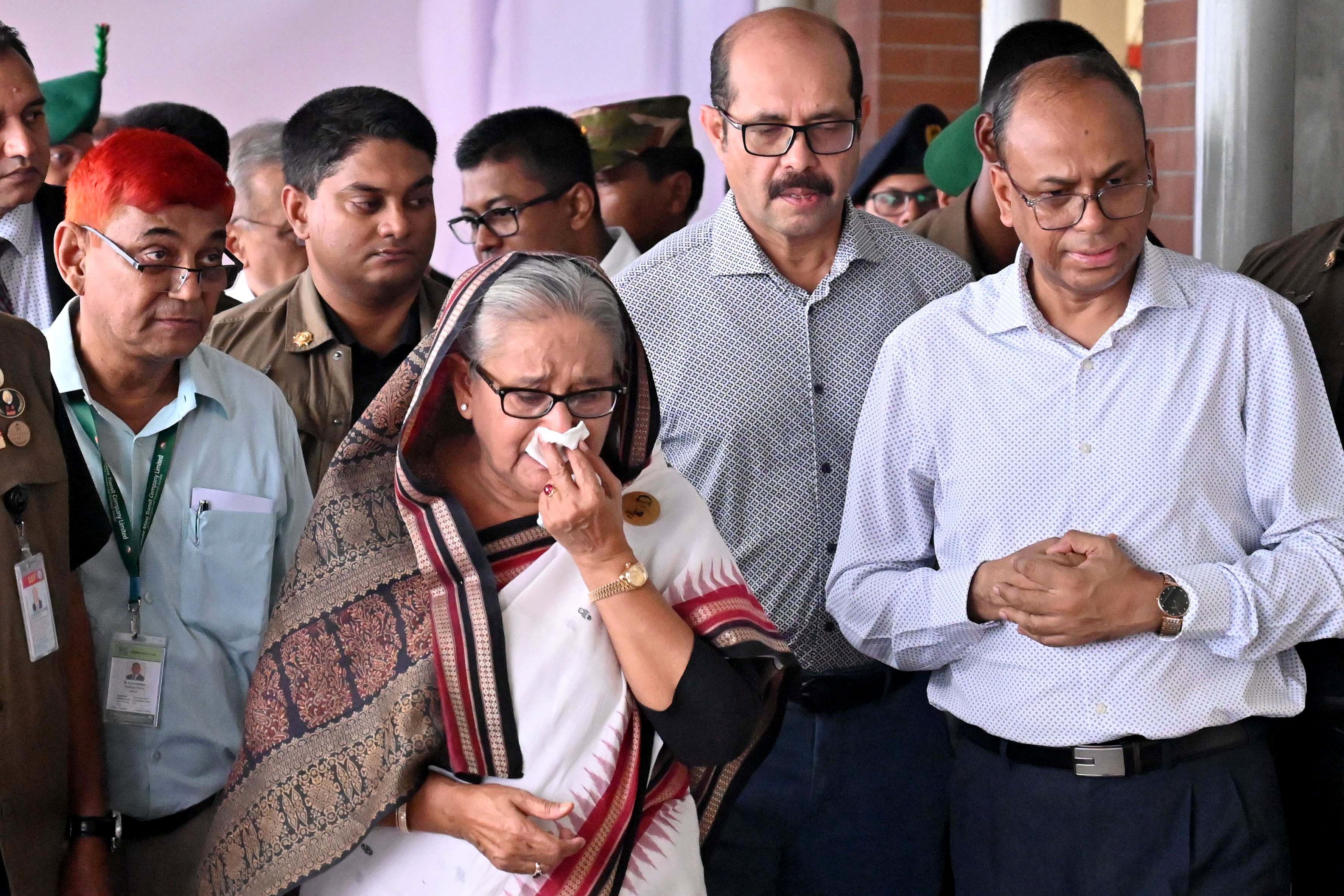 In this handout photograph taken and released on 25 July 2024 by Bangladesh Prime Minister’s Office, prime minister Sheikh Hasina weeps while she visits a metro station in Mirpur vandalized by students during the anti-quota protests